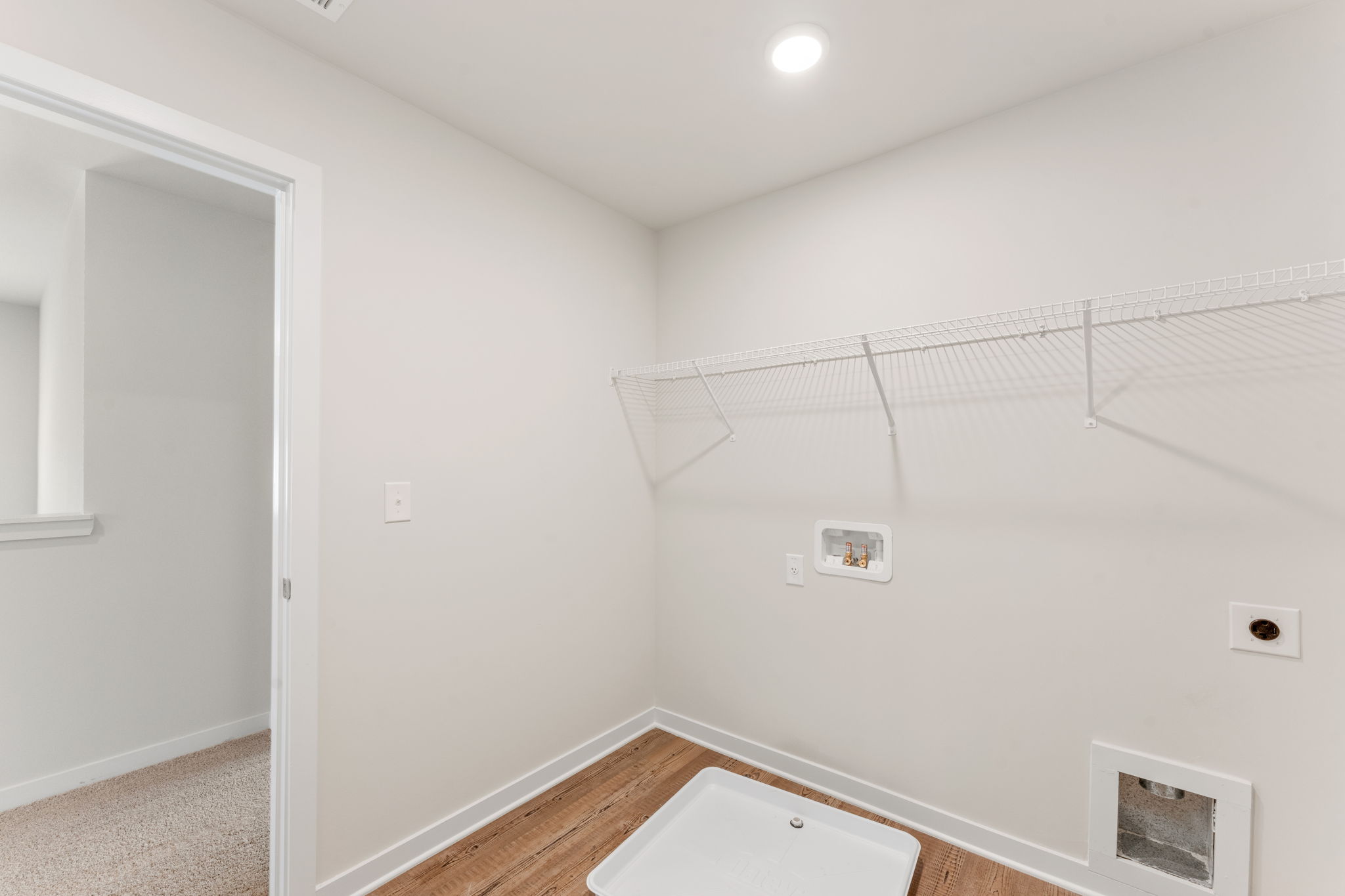 A room with a shower and a wood floor.