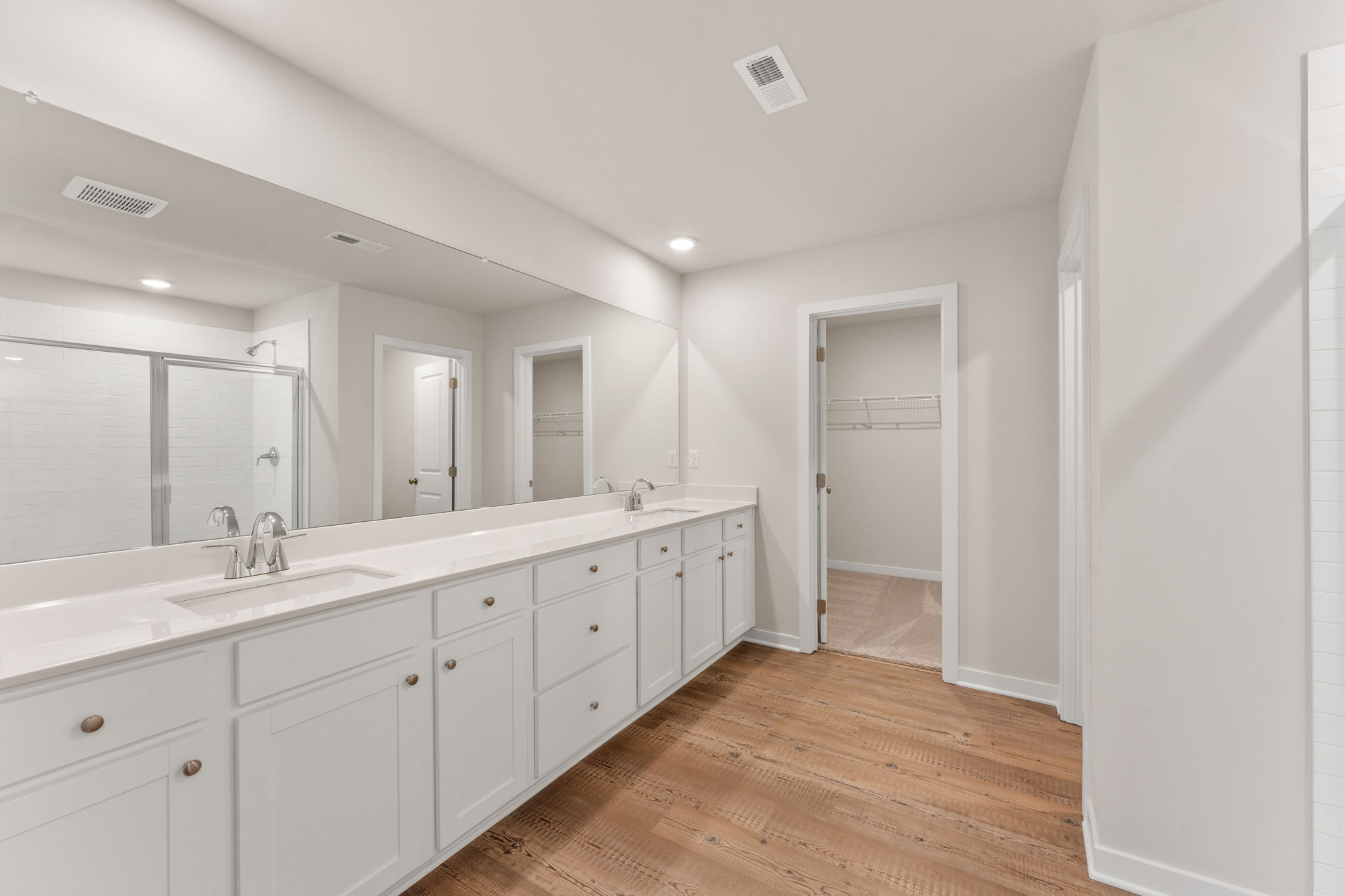 A bathroom with white cabinets.