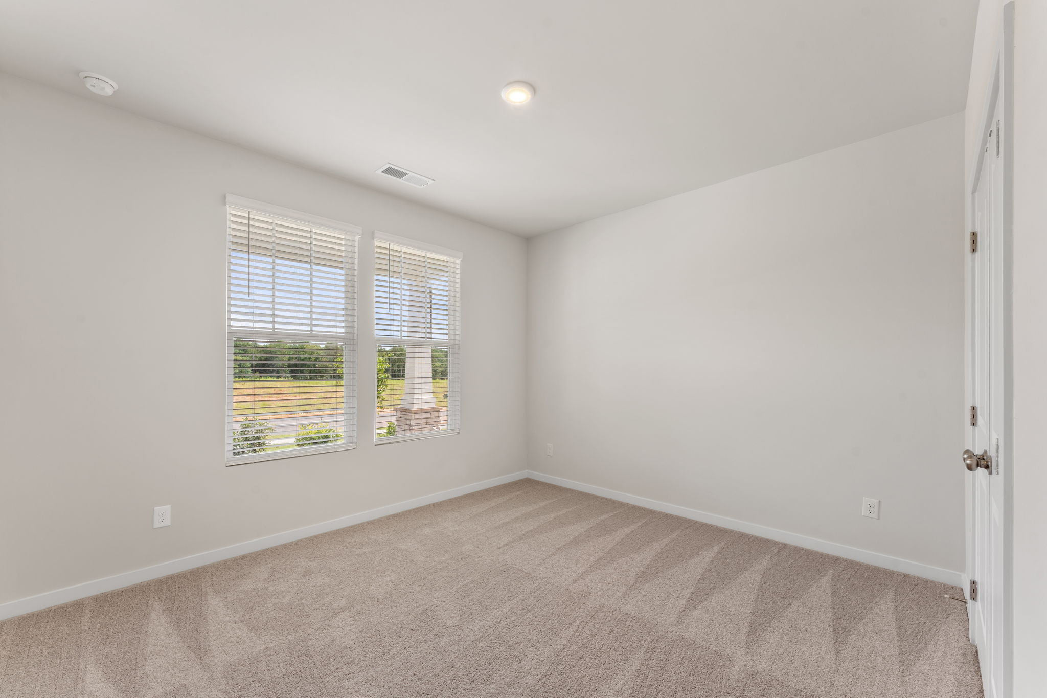A room with a carpet and a window.