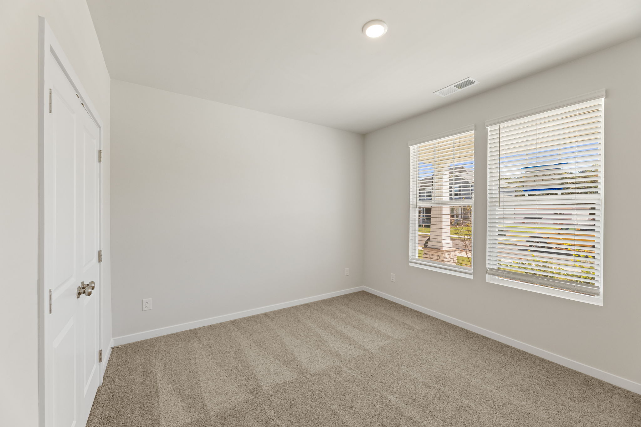 A room with a carpet and a window.