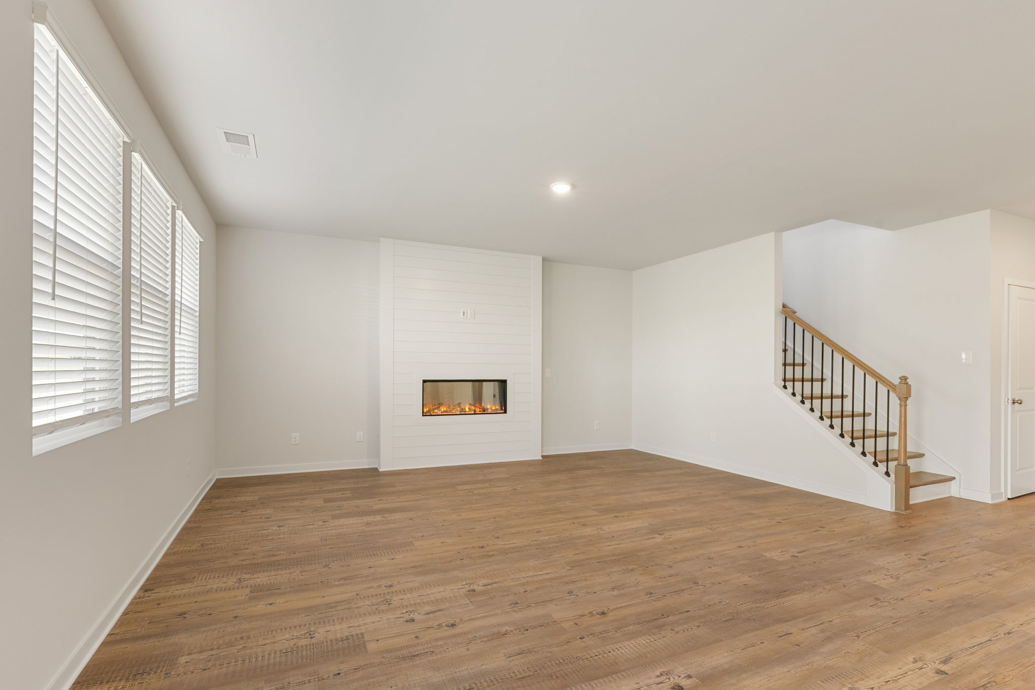 A room with a fireplace and wood floors.