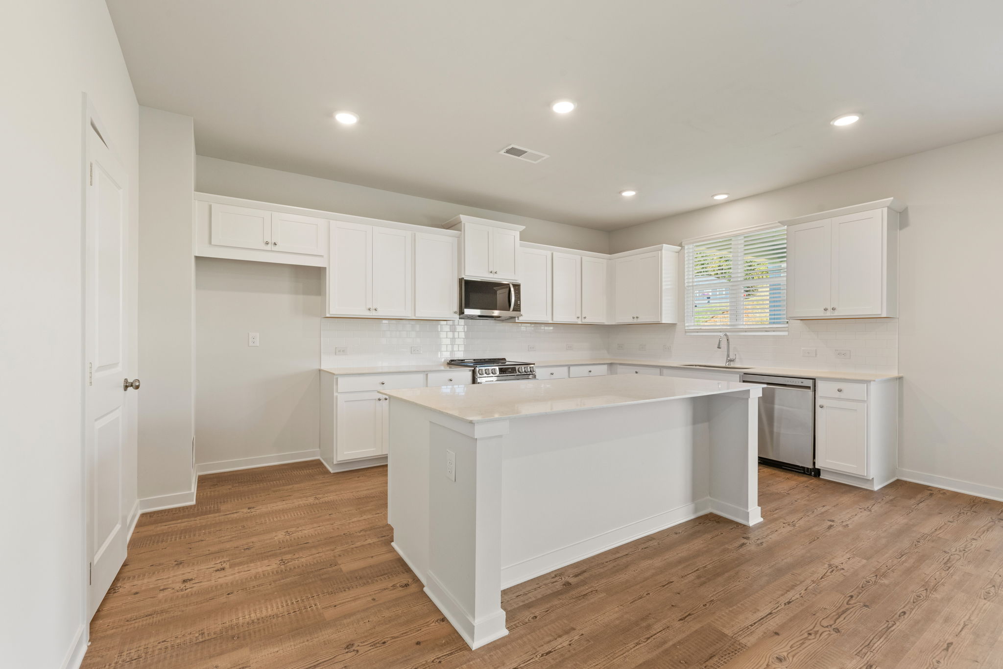 A kitchen with white cabinets.