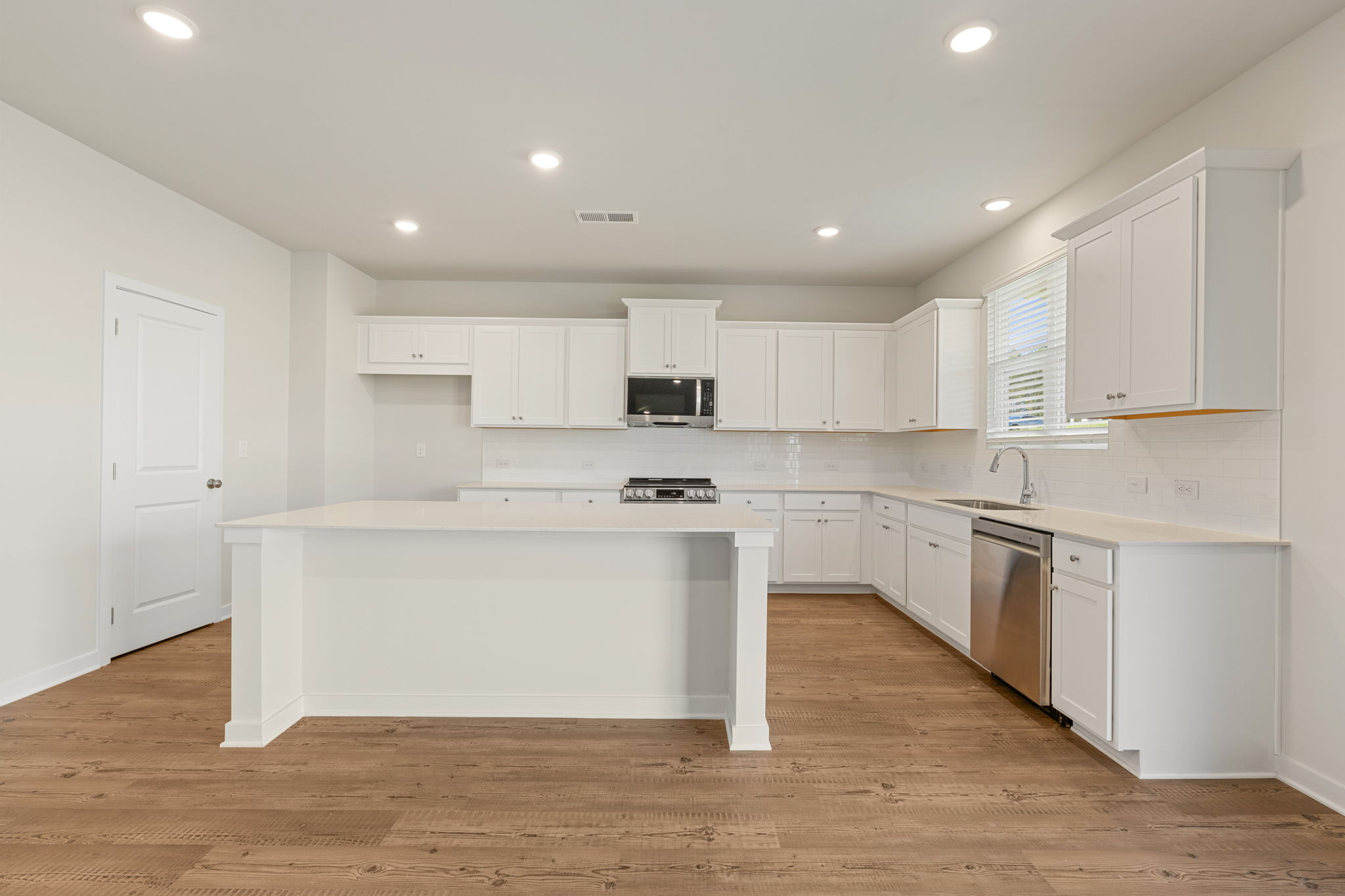 A kitchen with white cabinets.