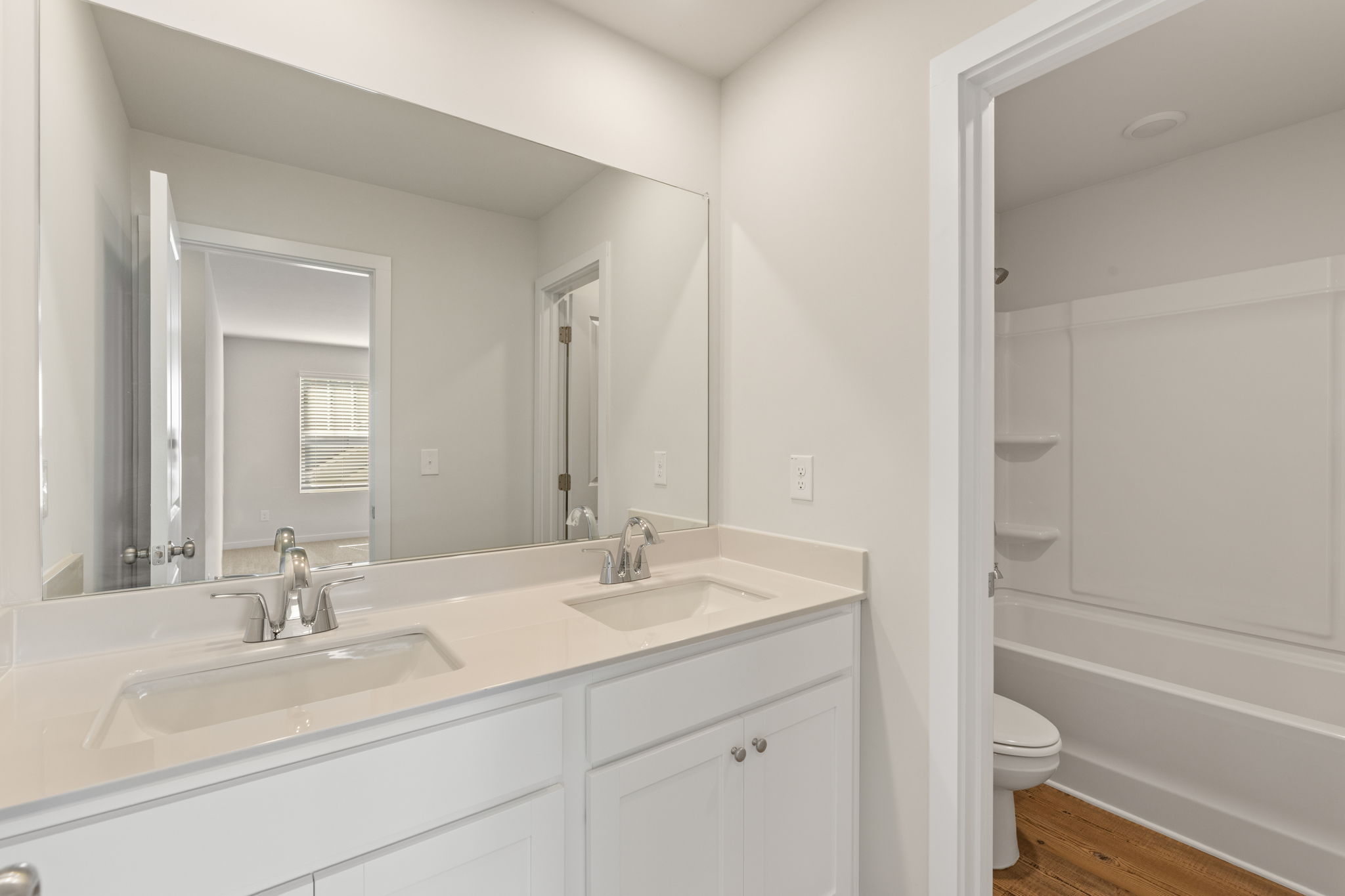 A bathroom with a large mirror.