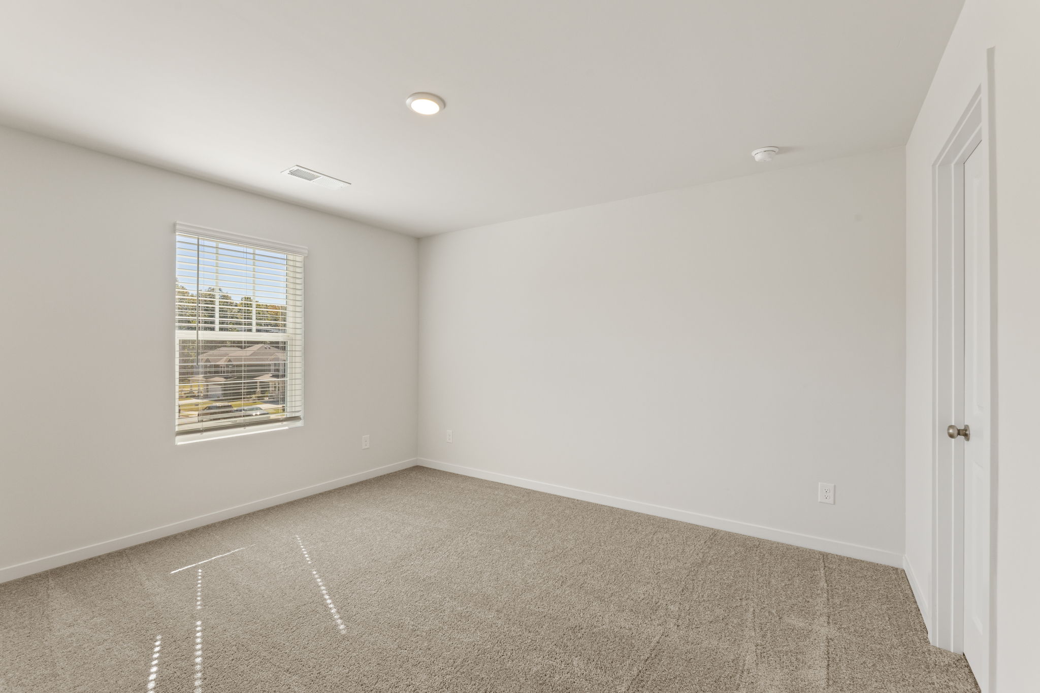 A room with a window and a carpet.