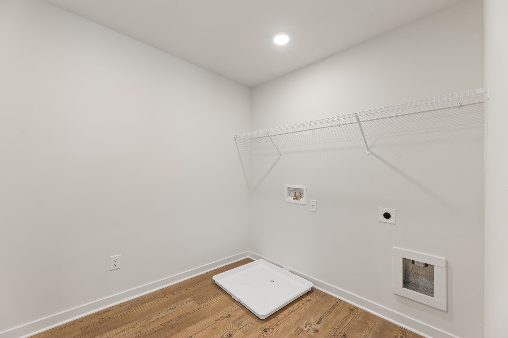A white room with a wood floor.