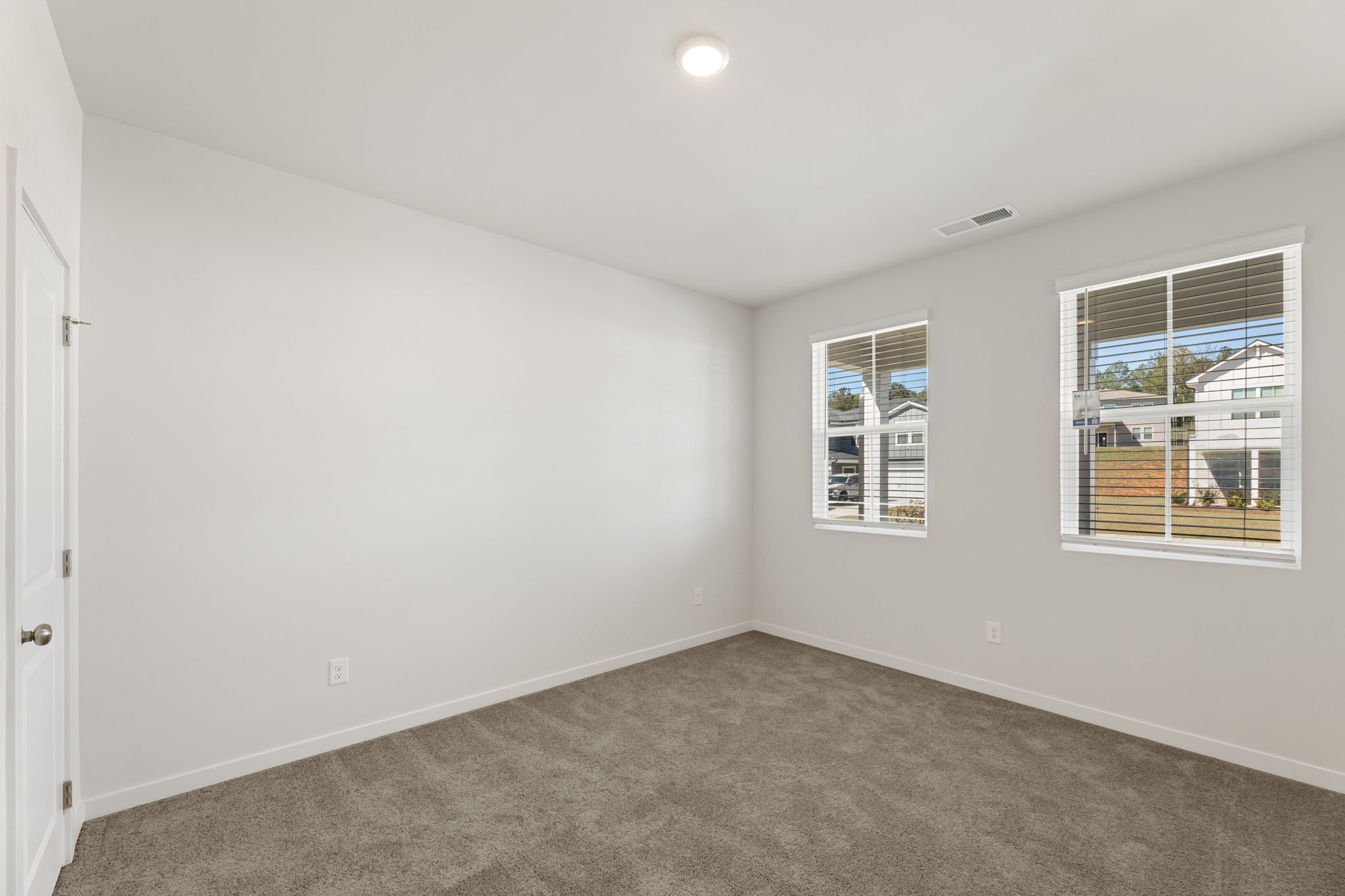 A room with windows and a carpet.