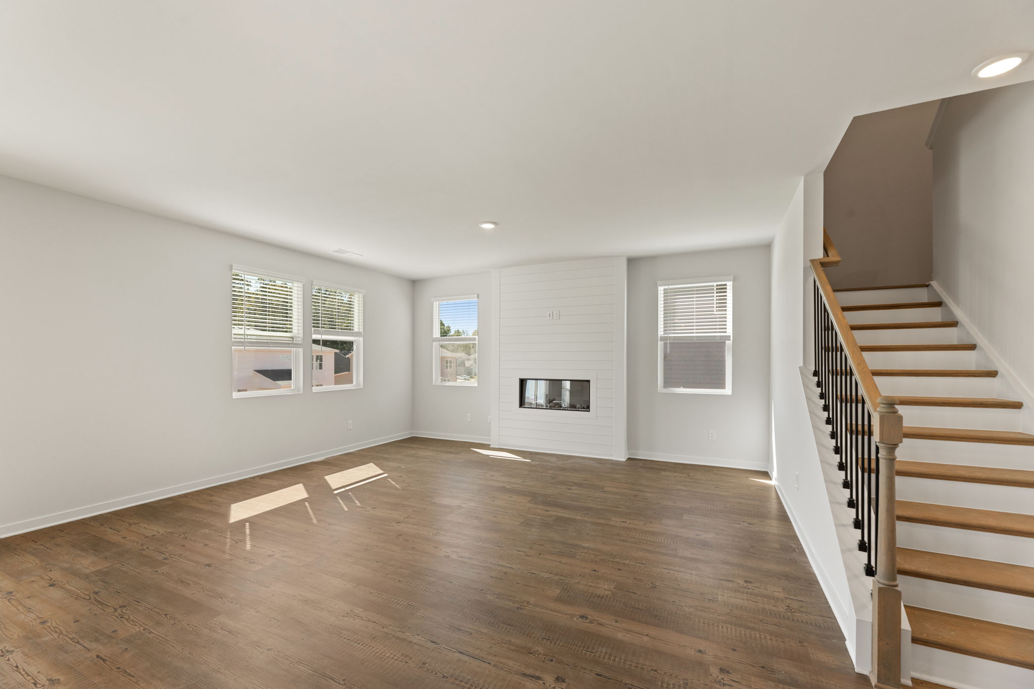 A room with a wood floor and a staircase.