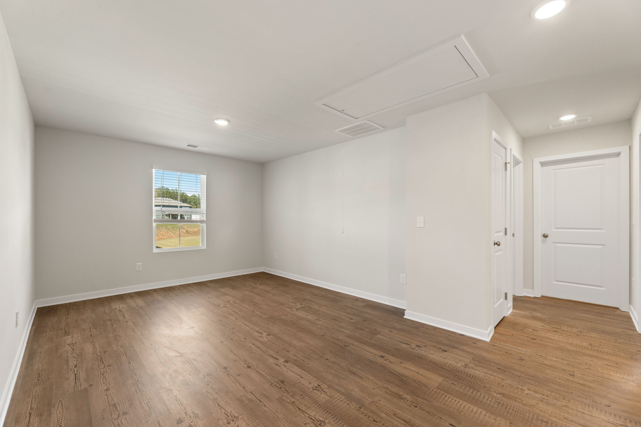 A room with white walls and wood floors.