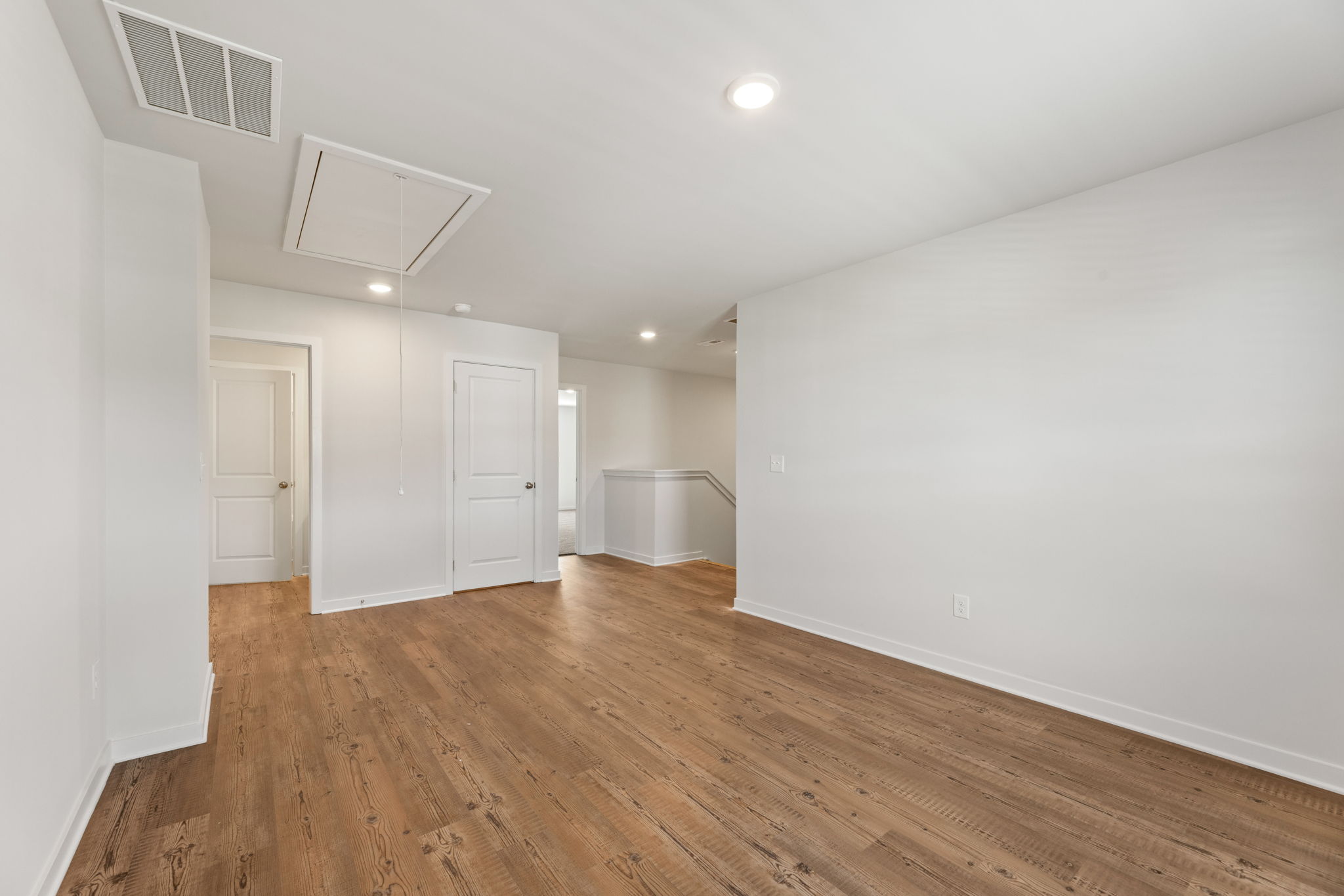 A room with white walls and wood floors.
