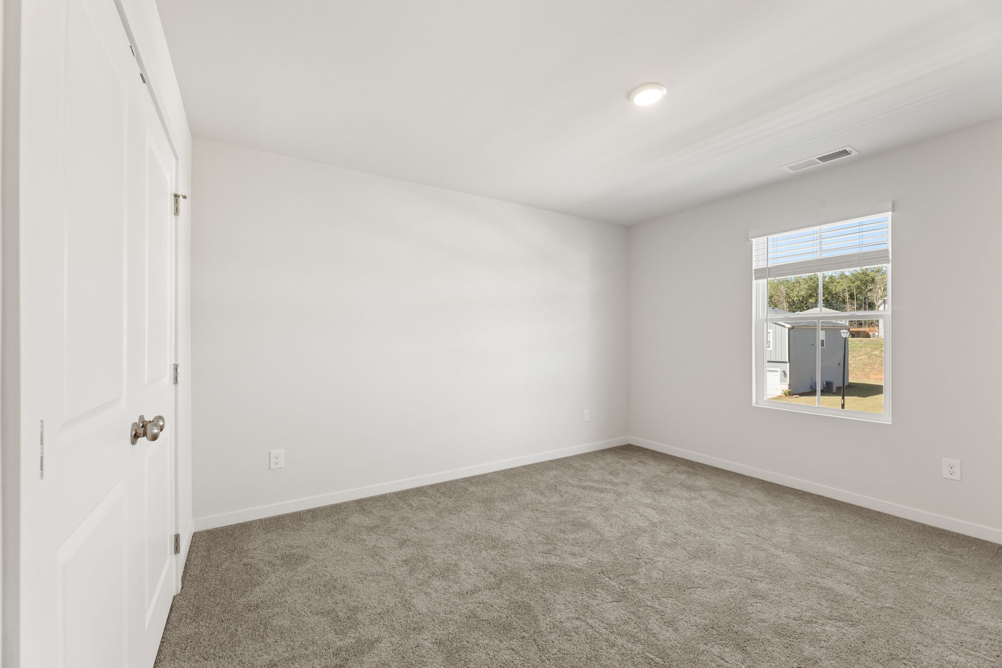 A room with a carpet and a window.