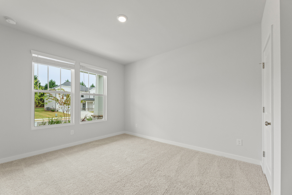 A room with a window and a carpet.