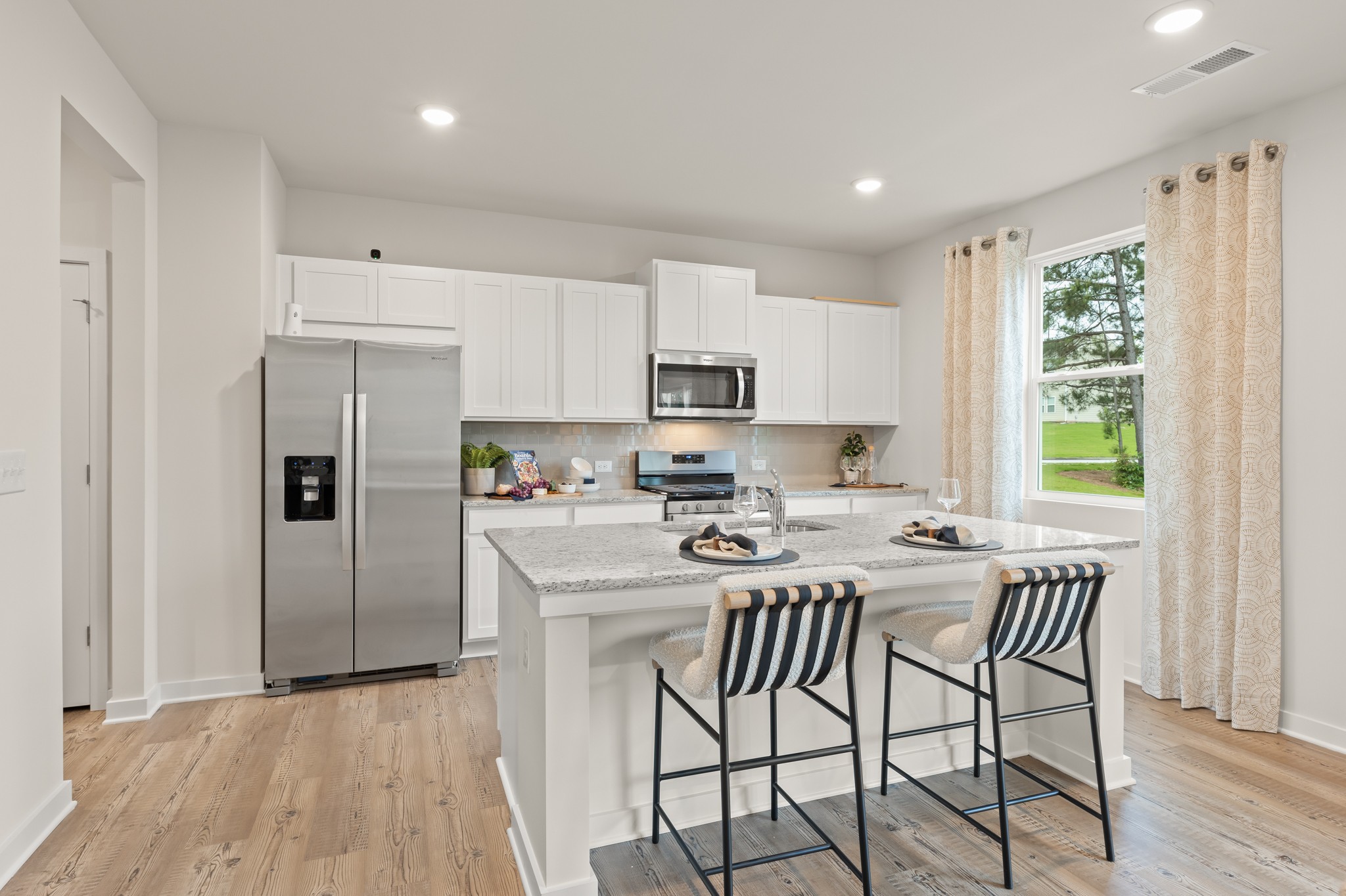 A kitchen with white cabinets.