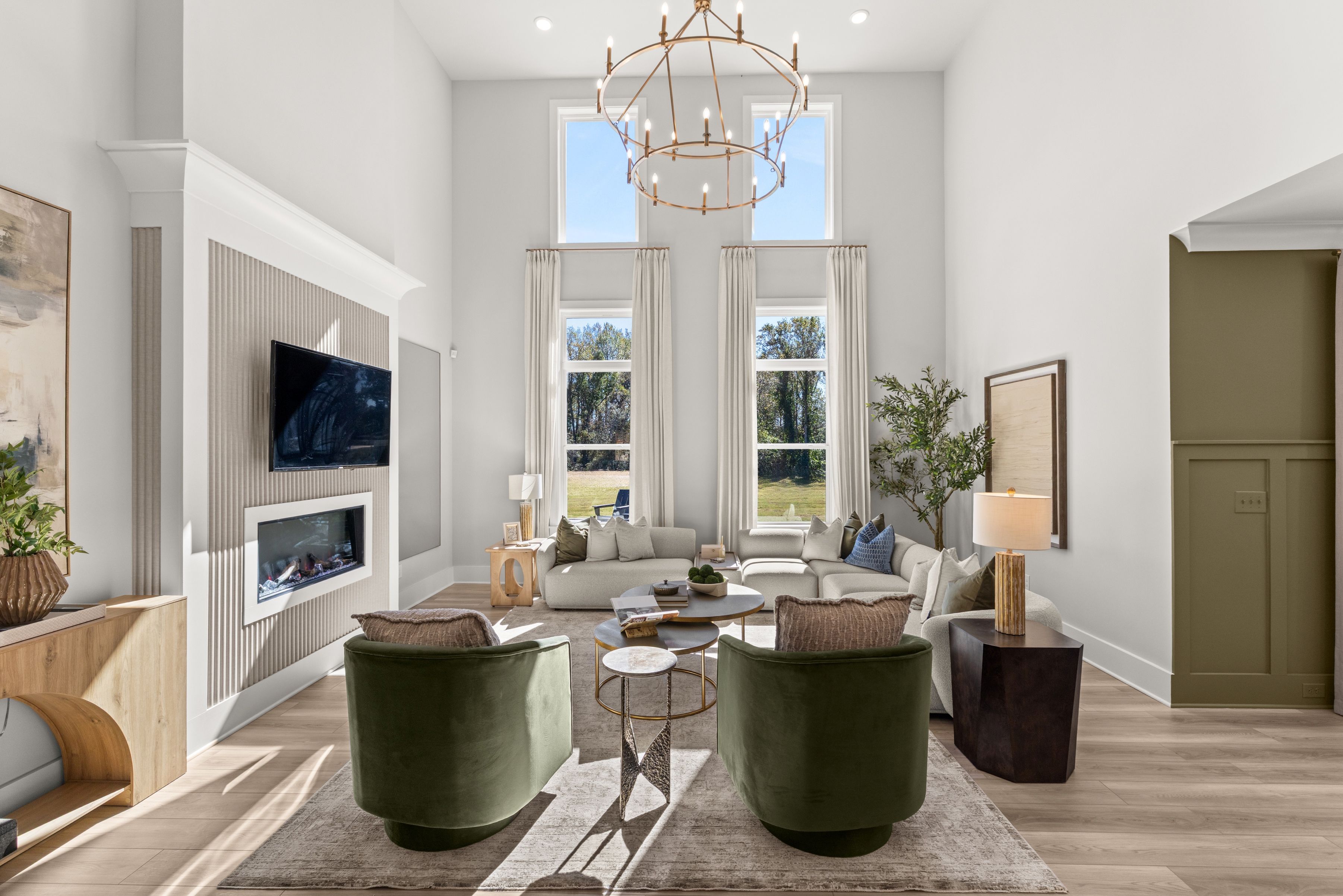 A living room with a chandelier and a large round table.