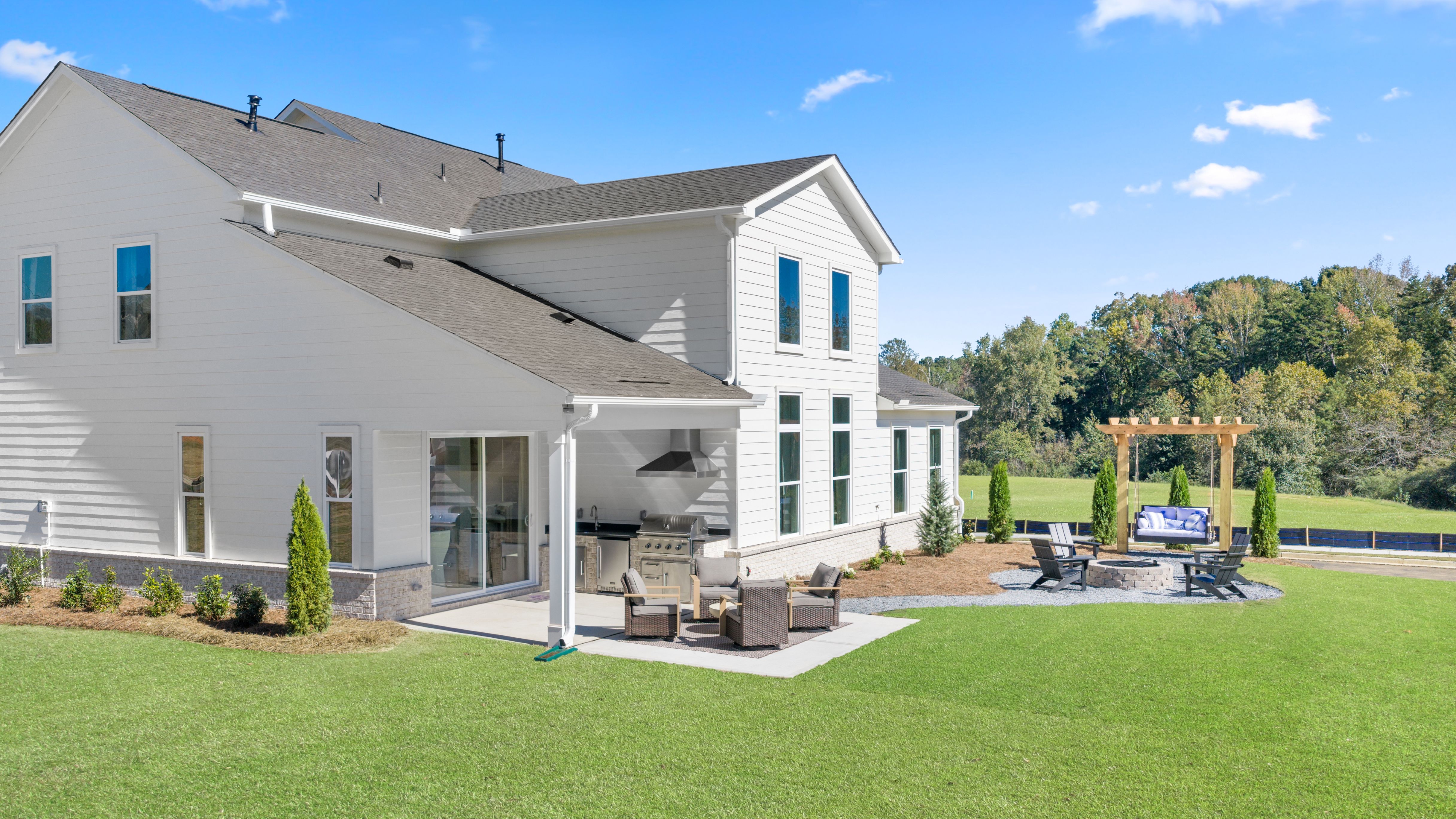 A house with a lawn and a play set in the front.