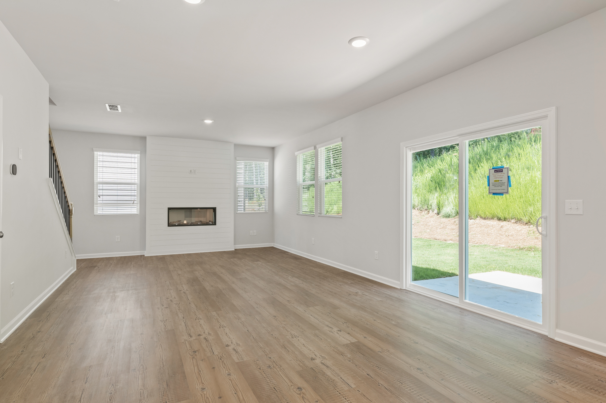 A room with a wood floor and a wood floor with a glass door.