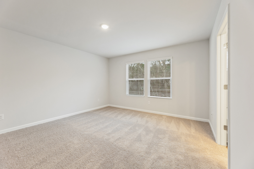 A room with a carpet and a window.