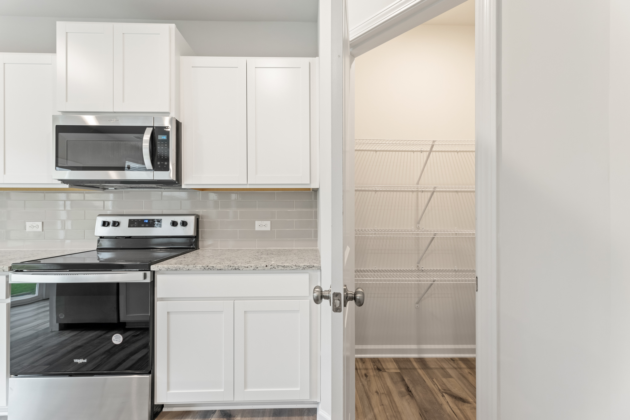 A kitchen with white cabinets.