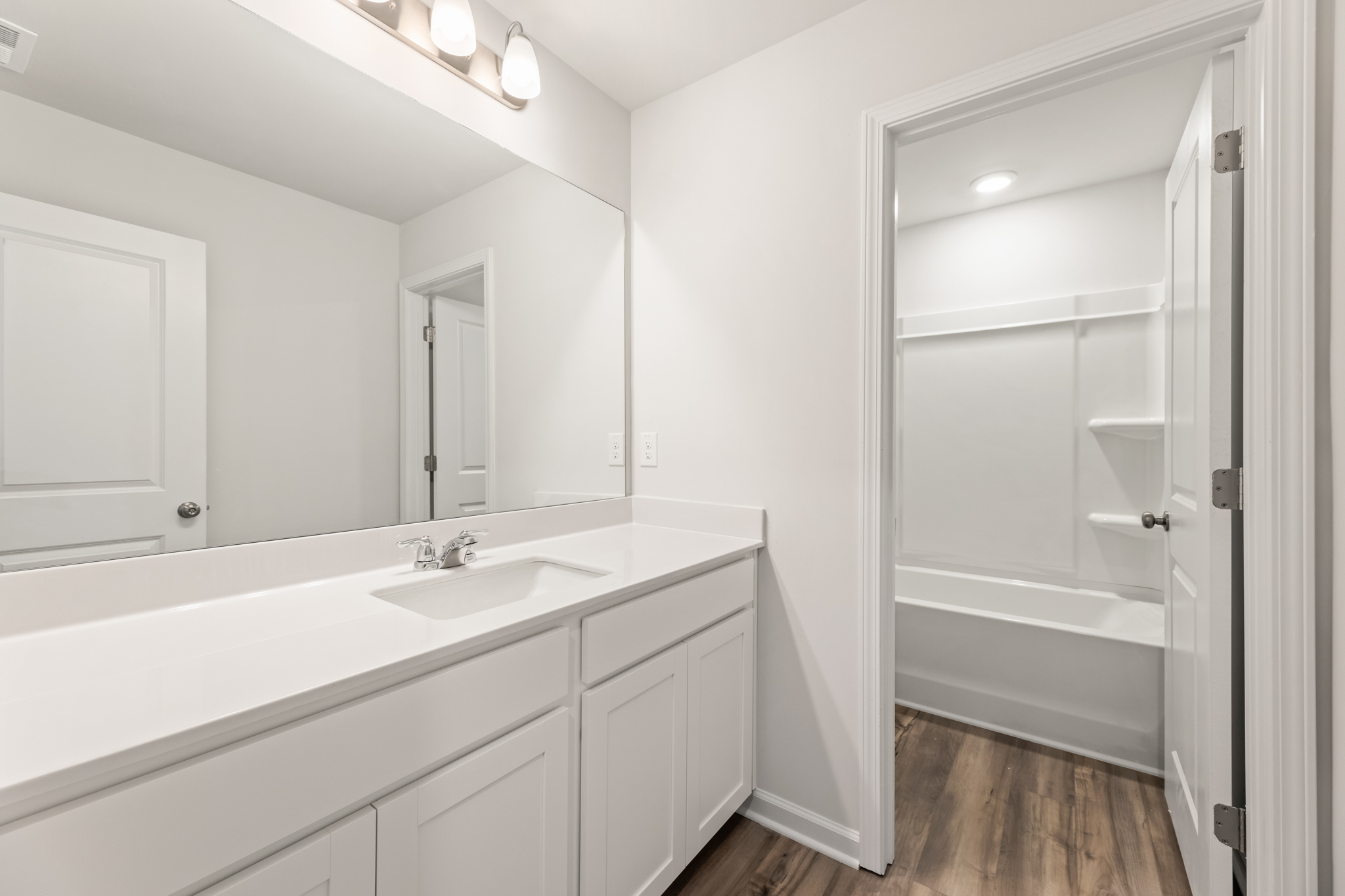 A bathroom with a sink and a shower unit.