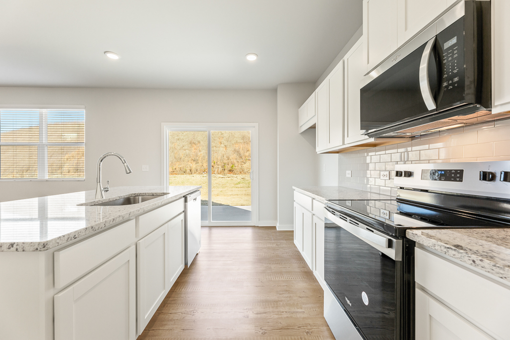 A kitchen with white cabinets.