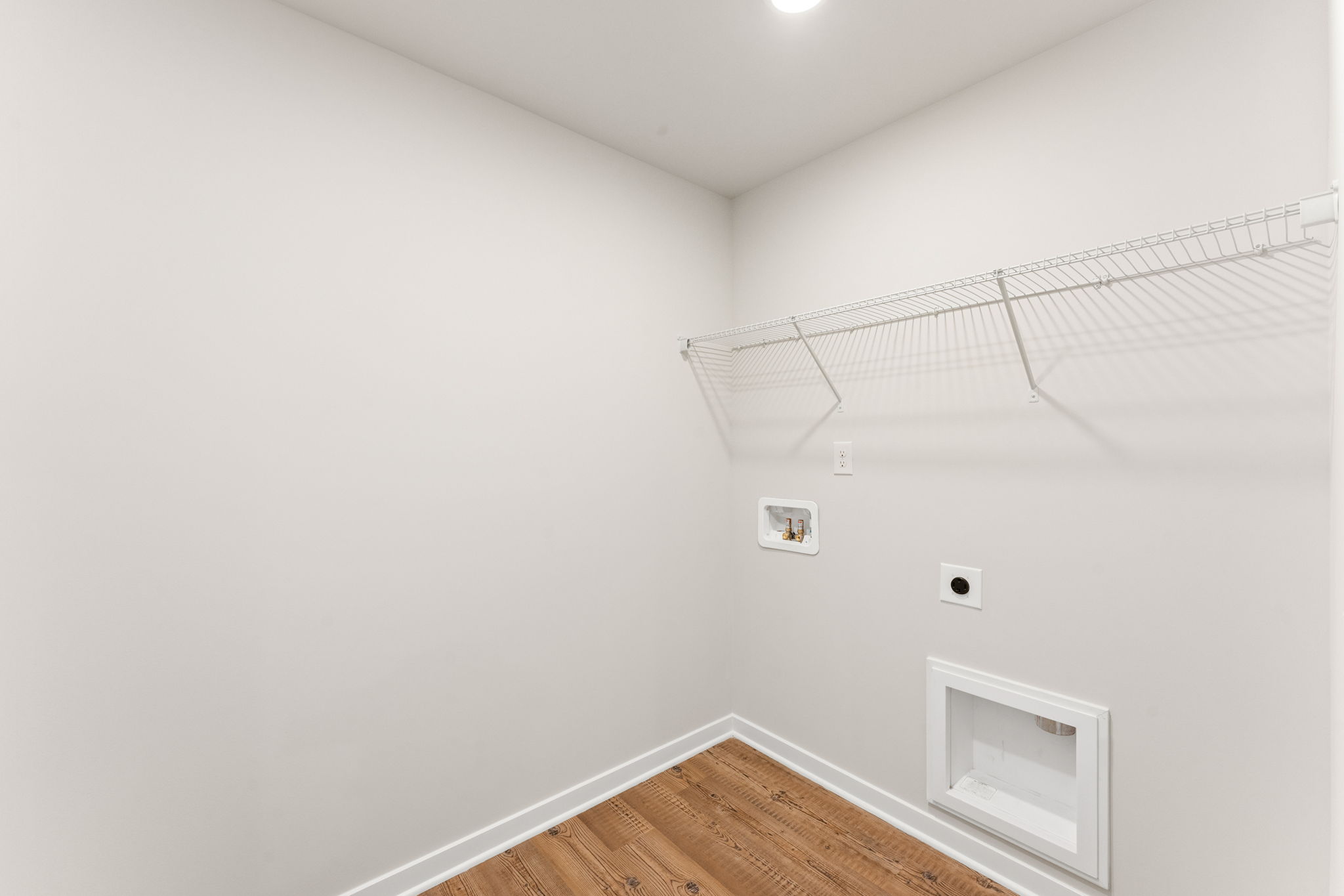 A room with a wood floor and white walls.