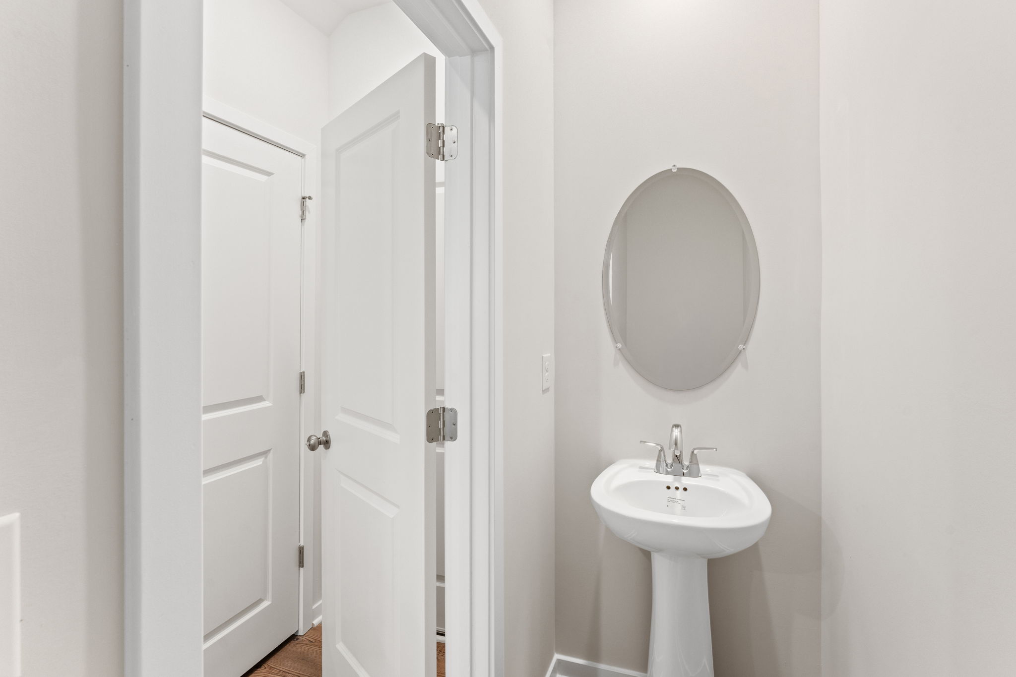 A bathroom with a round mirror.