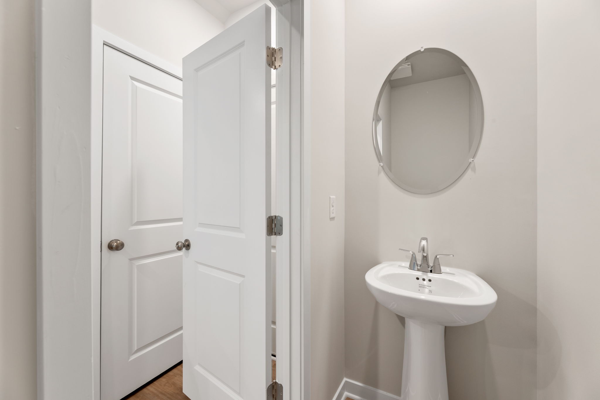A bathroom with a round mirror.