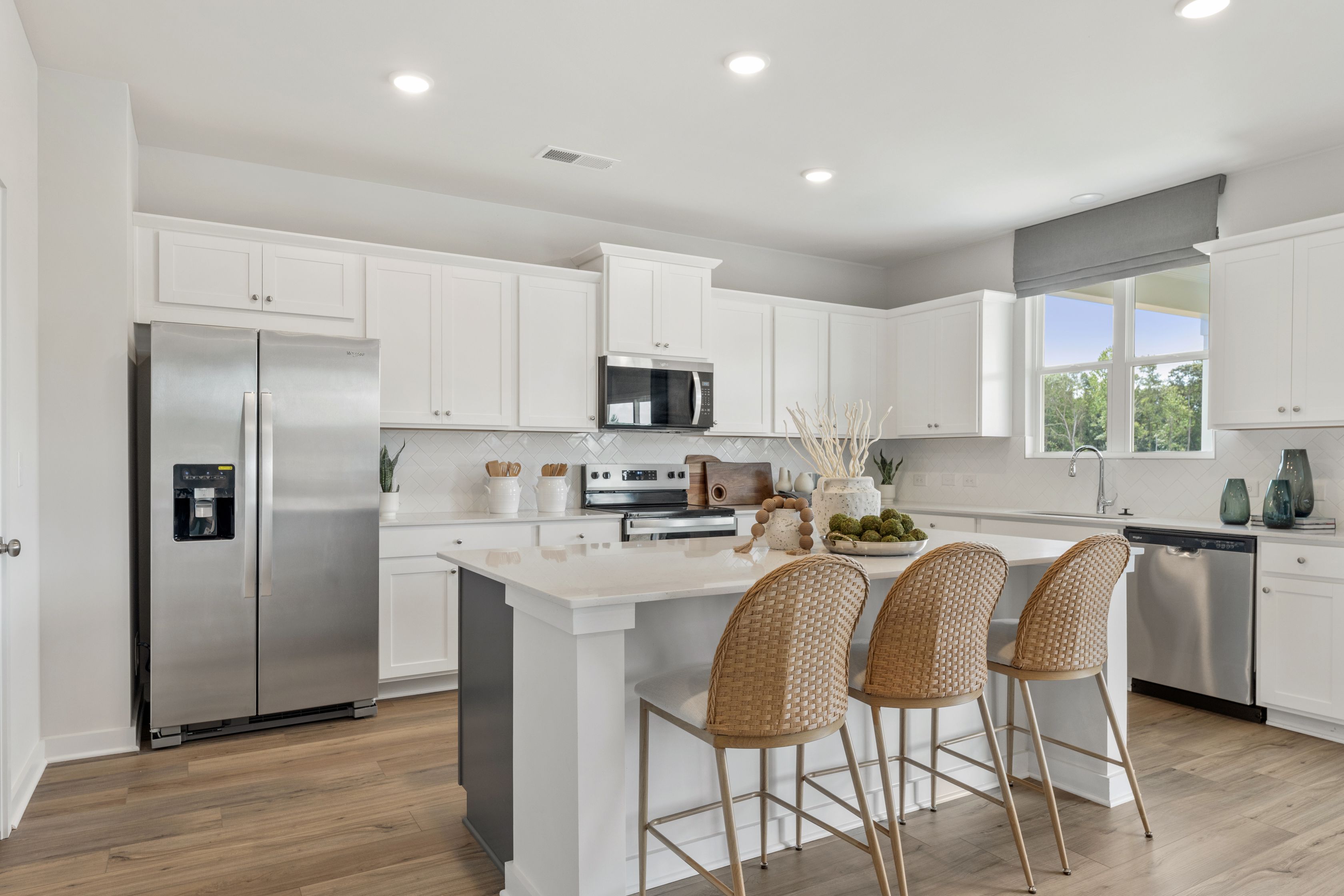 A kitchen with white cabinets.