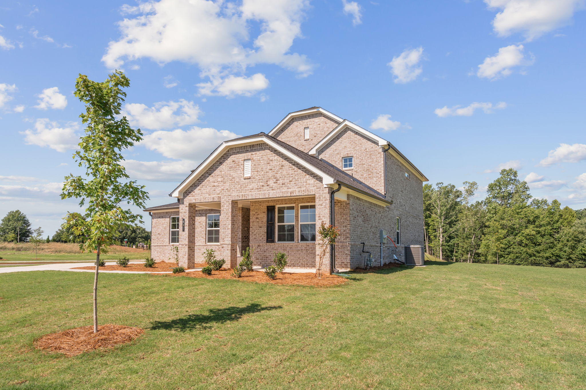 A brick house with a tree in front of it.