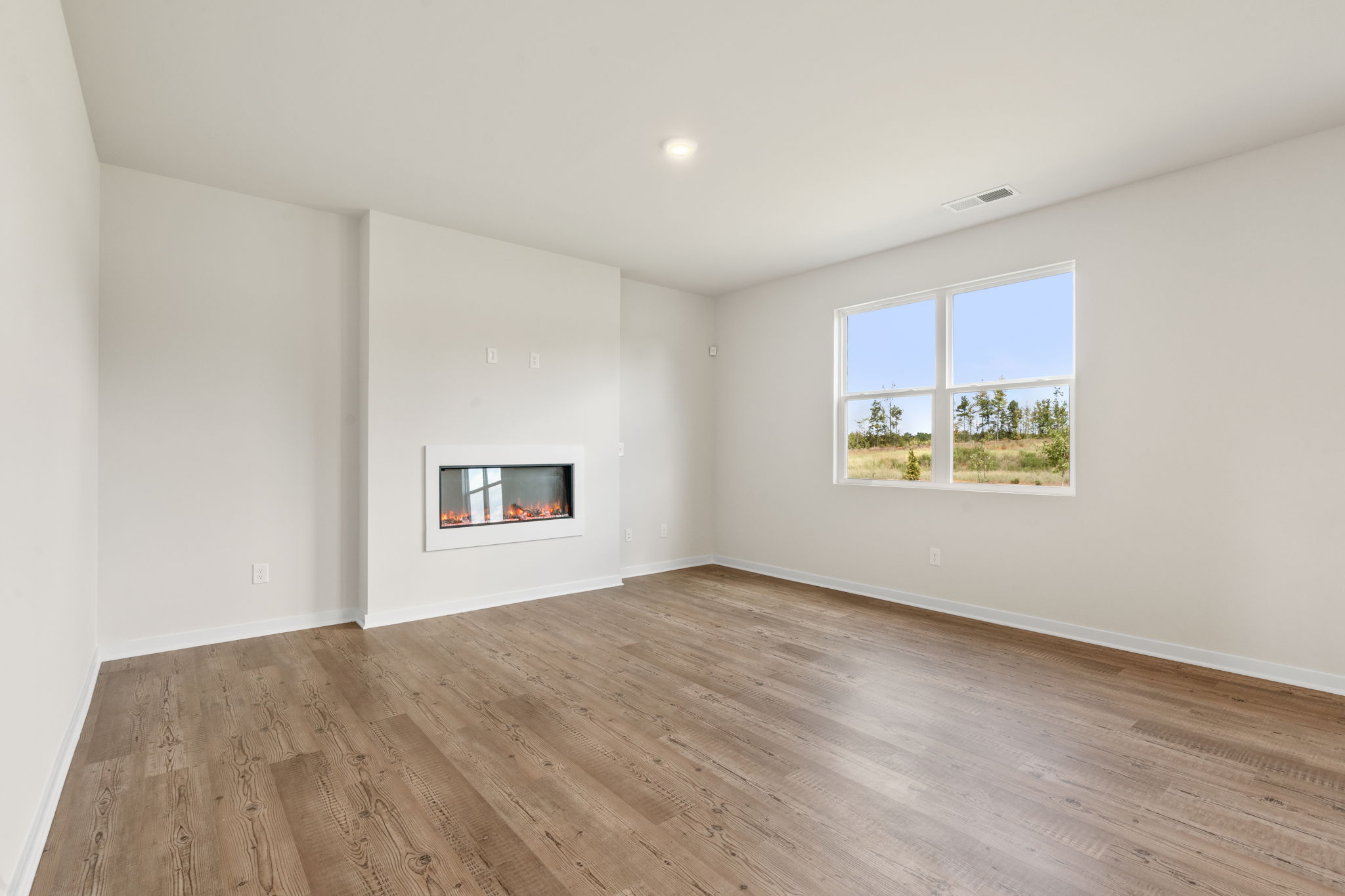A room with a wood floor and windows.
