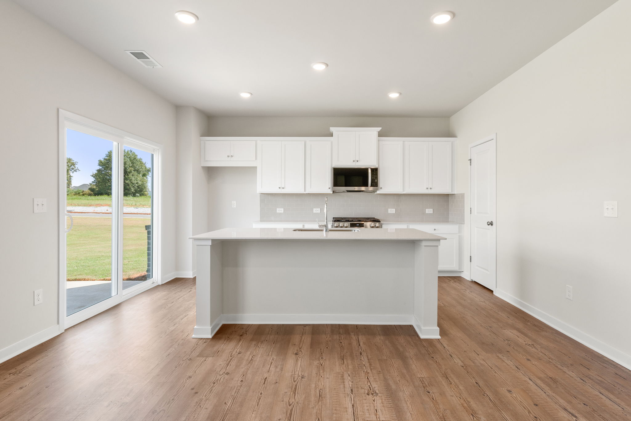 A kitchen with white cabinets.
