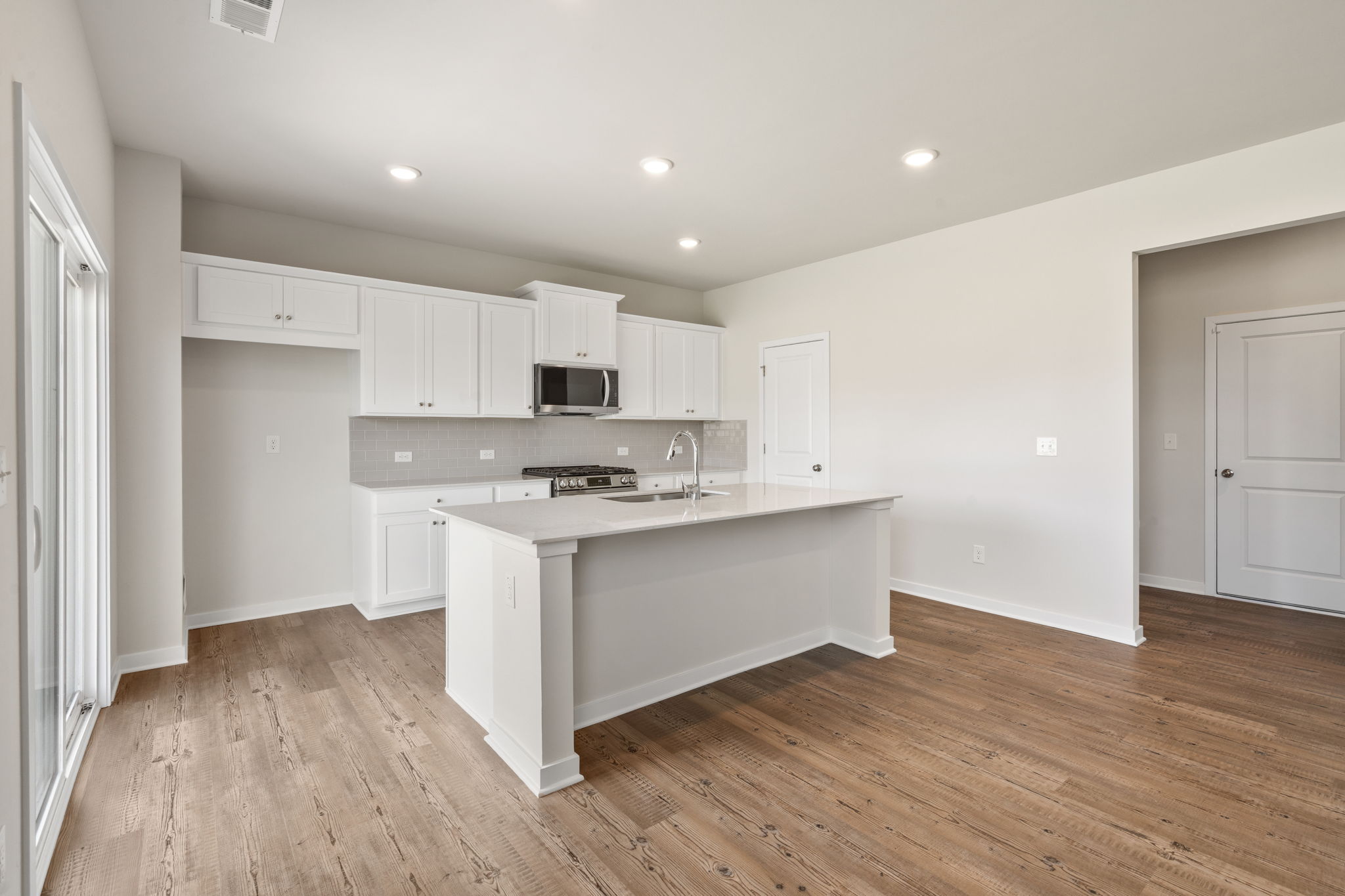 A kitchen with white cabinets.