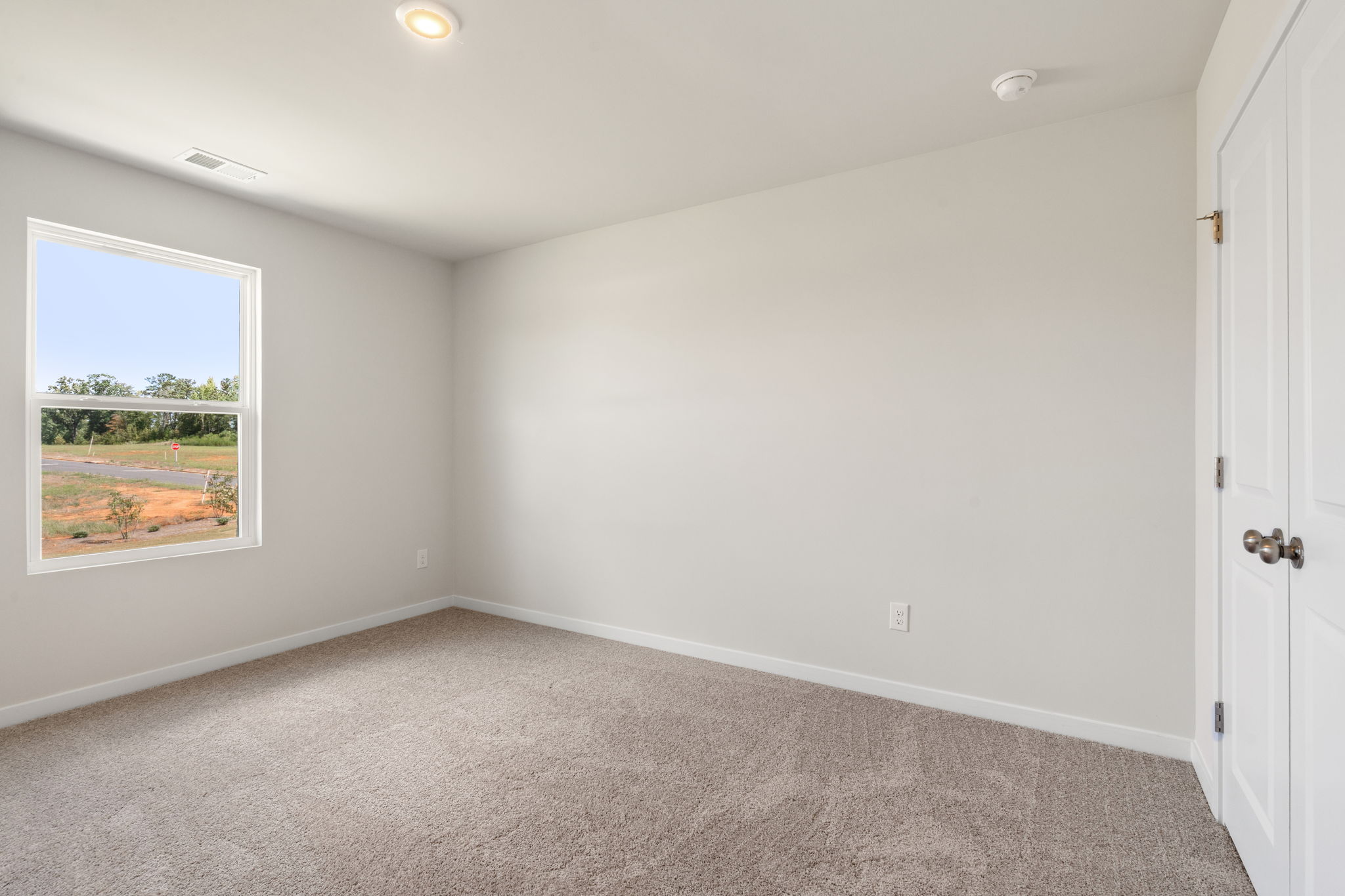 A room with a window and a carpet.