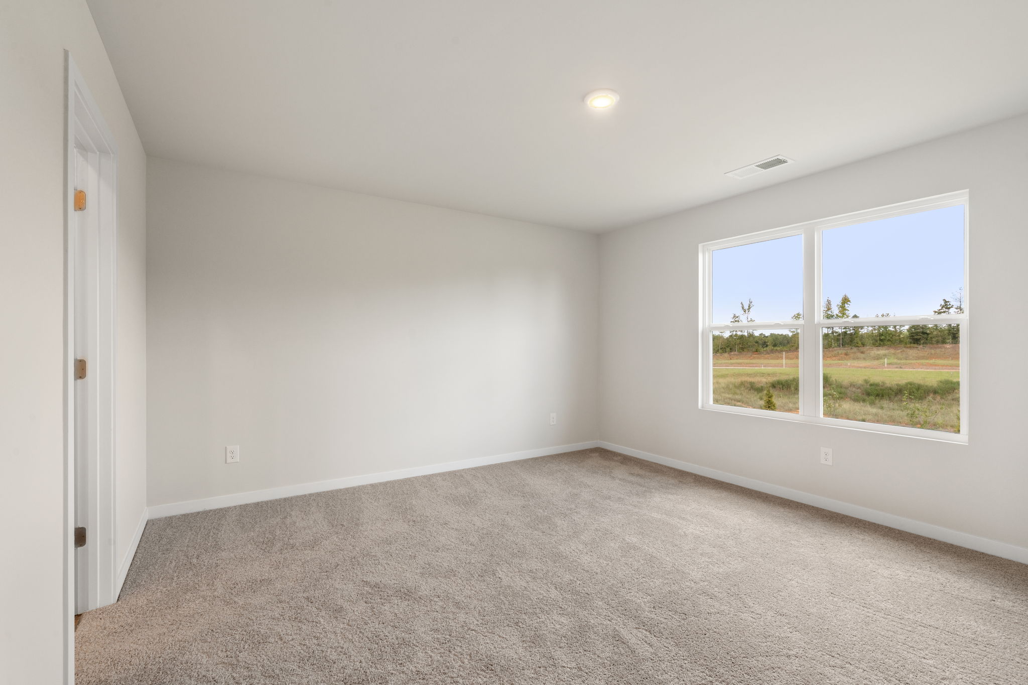 A room with windows and a carpet.