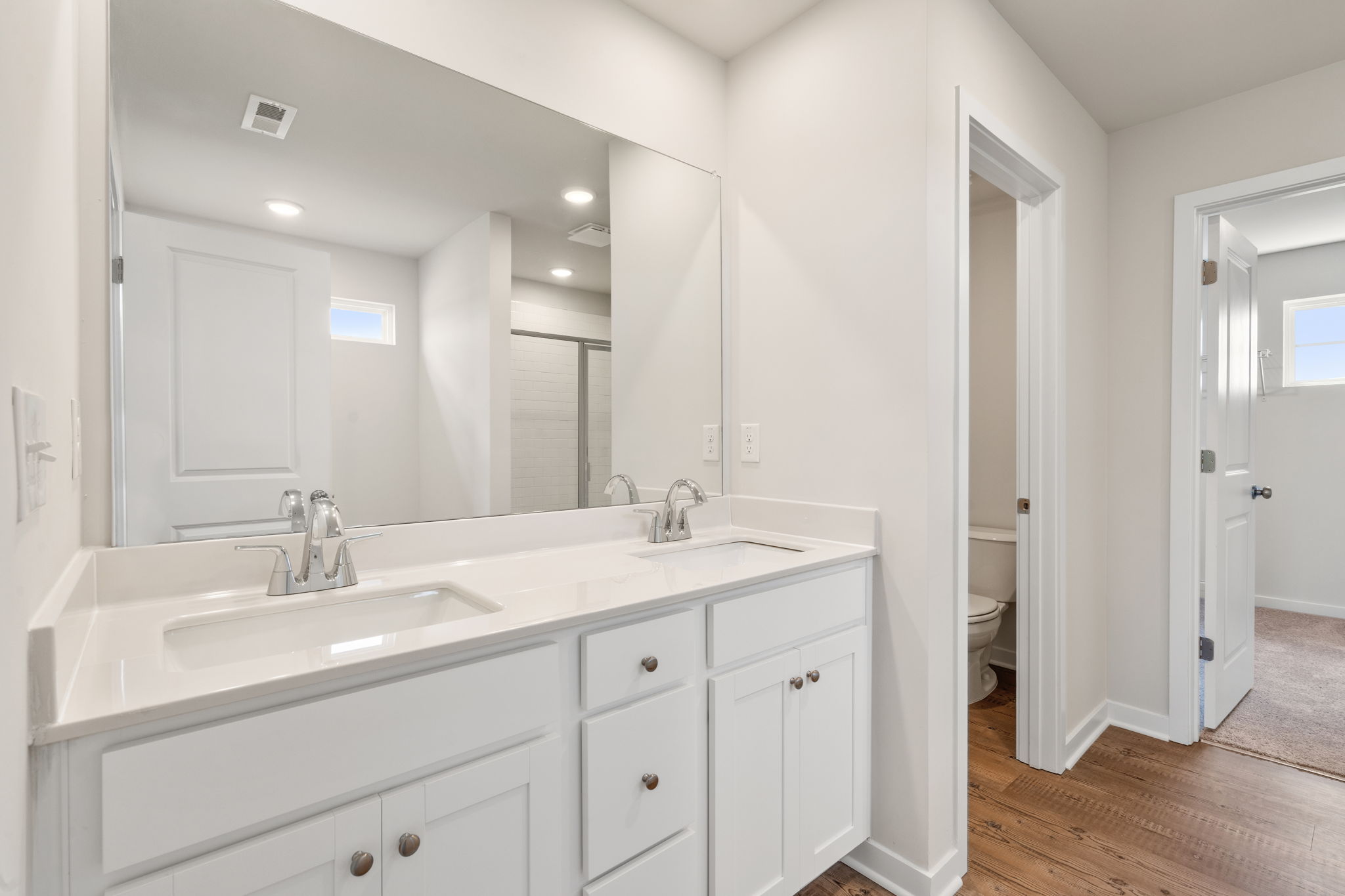 A bathroom with white cabinets.