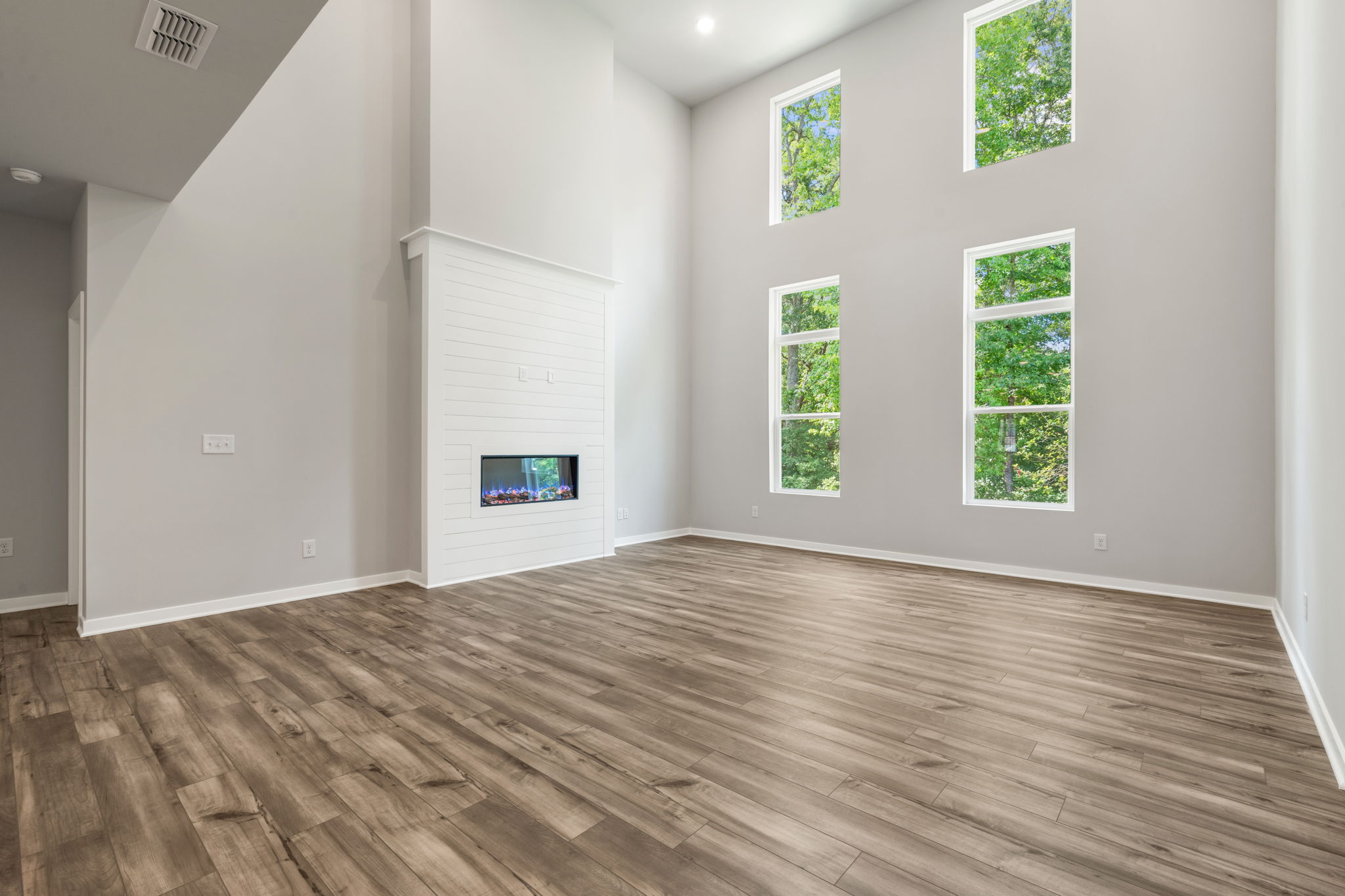 A room with a wood floor and windows.
