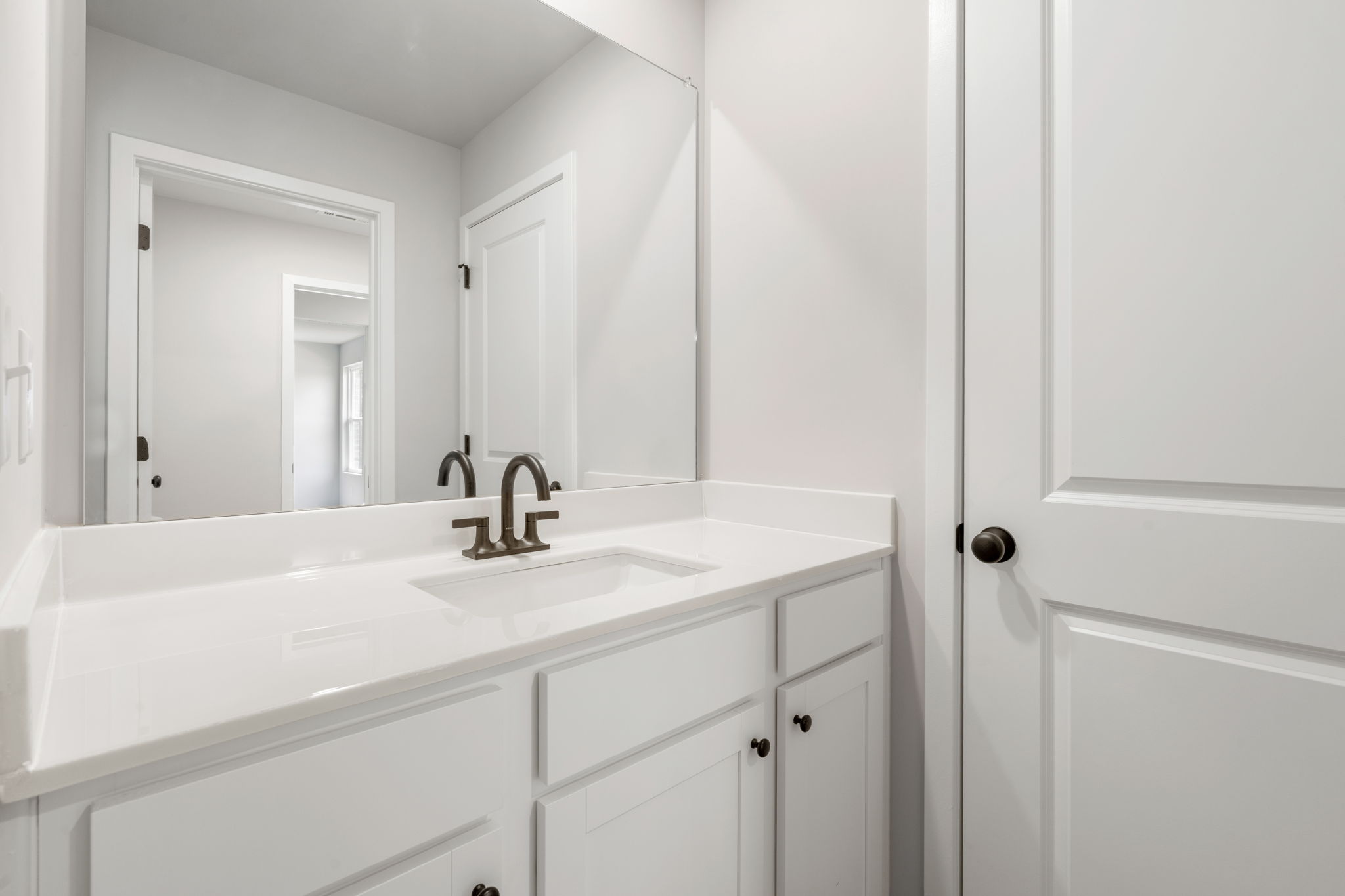 A bathroom with white cabinets.