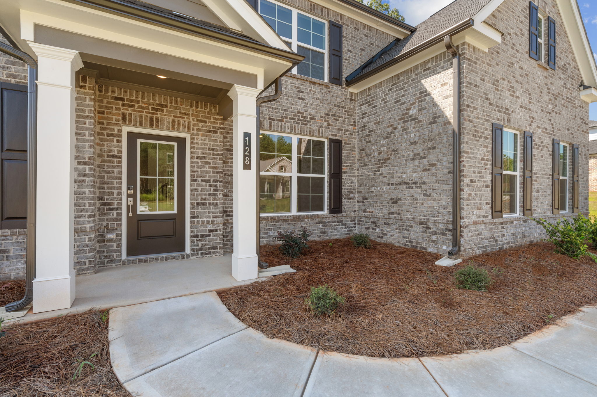 A brick building with a front yard.