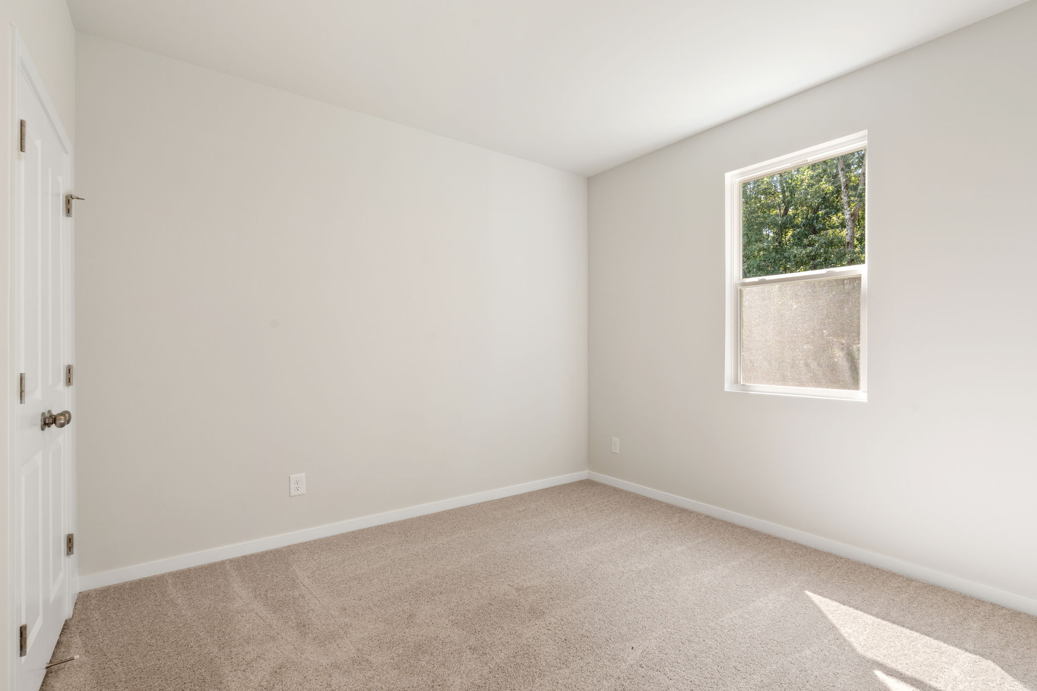 A room with a window and a carpet.