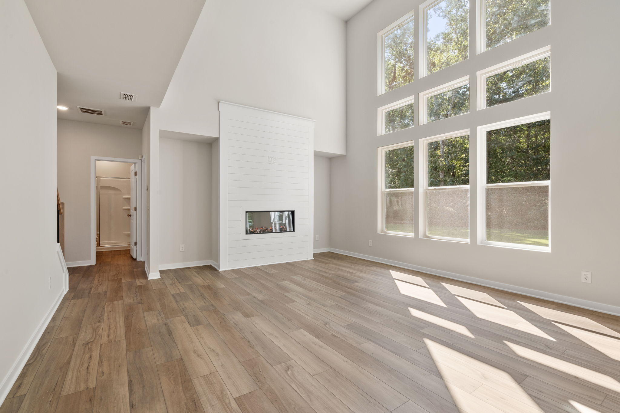 A room with a wood floor and a window with a painting on it.
