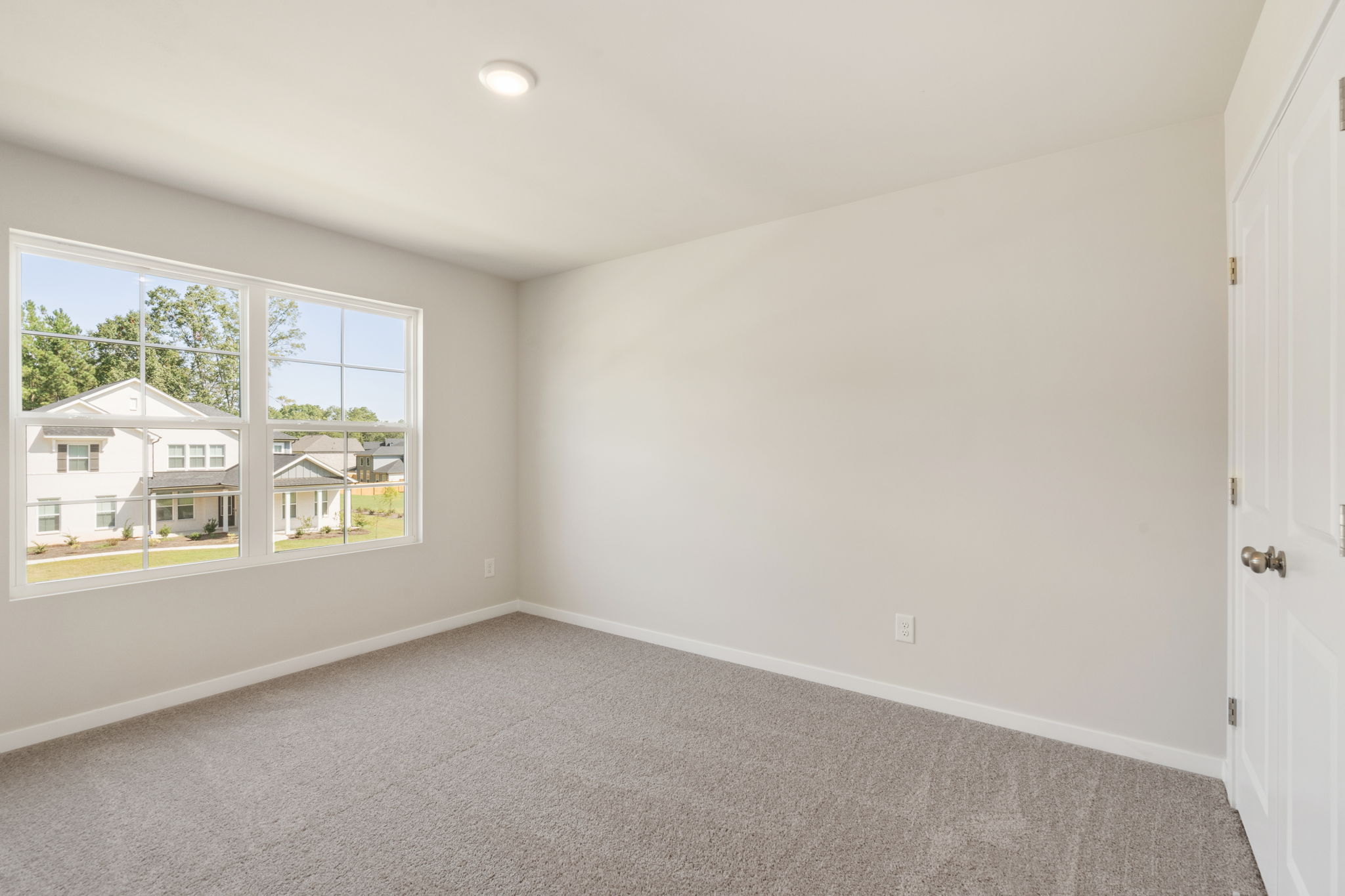 A room with a carpet and a window.