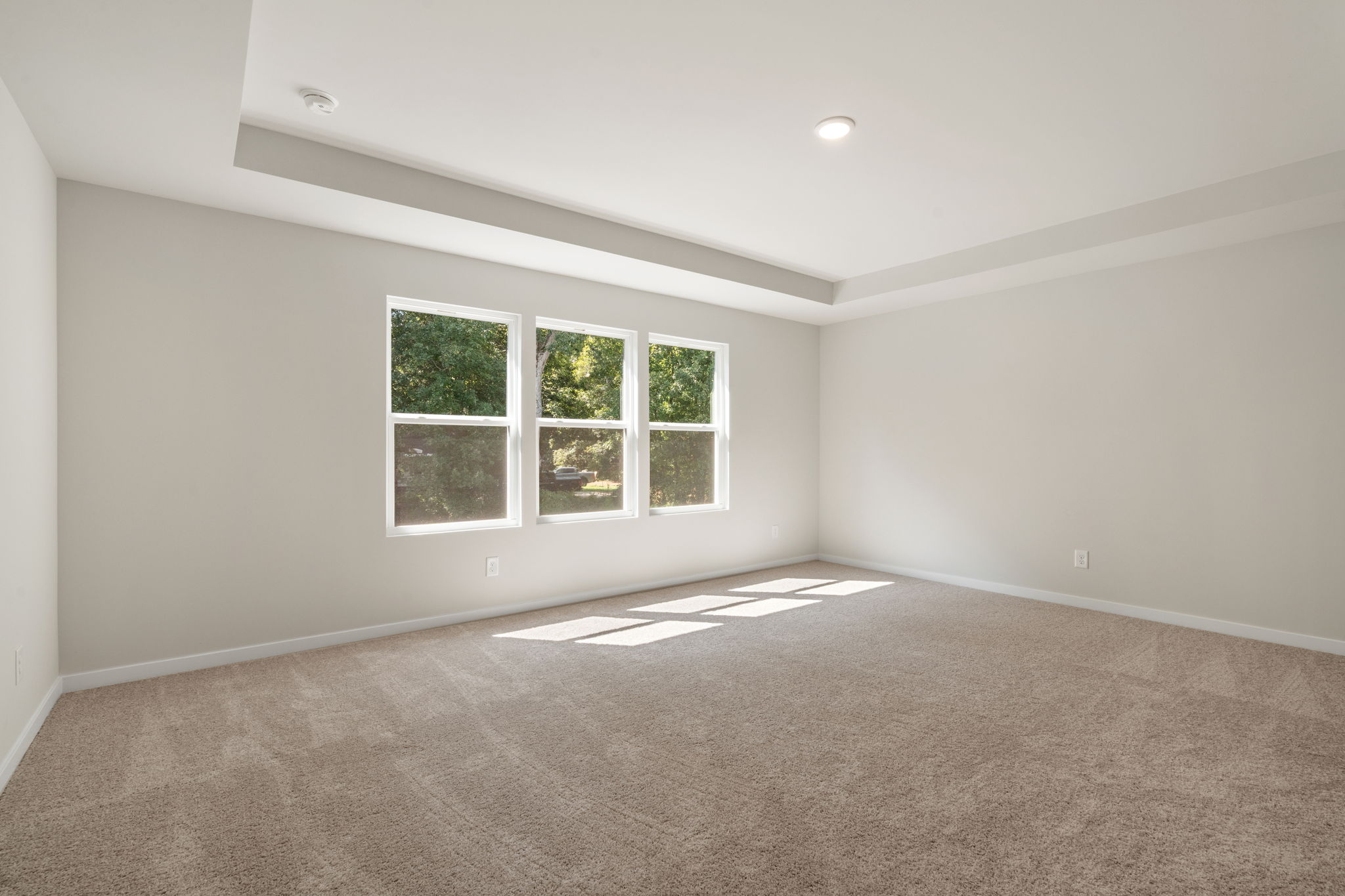 A room with a carpet and a window.