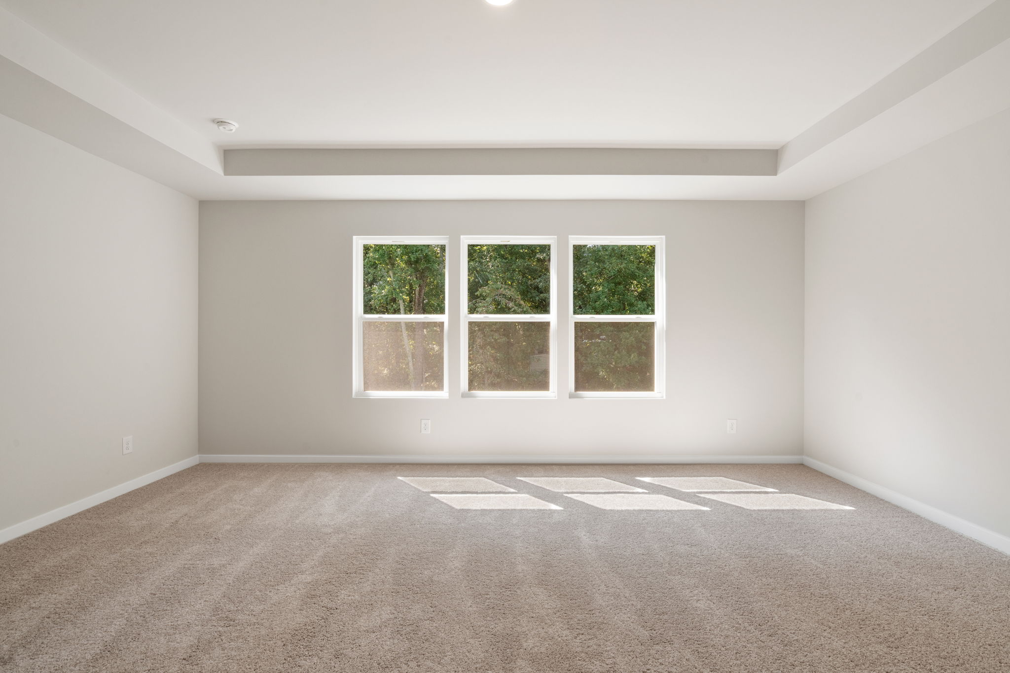A room with a window and a carpet.