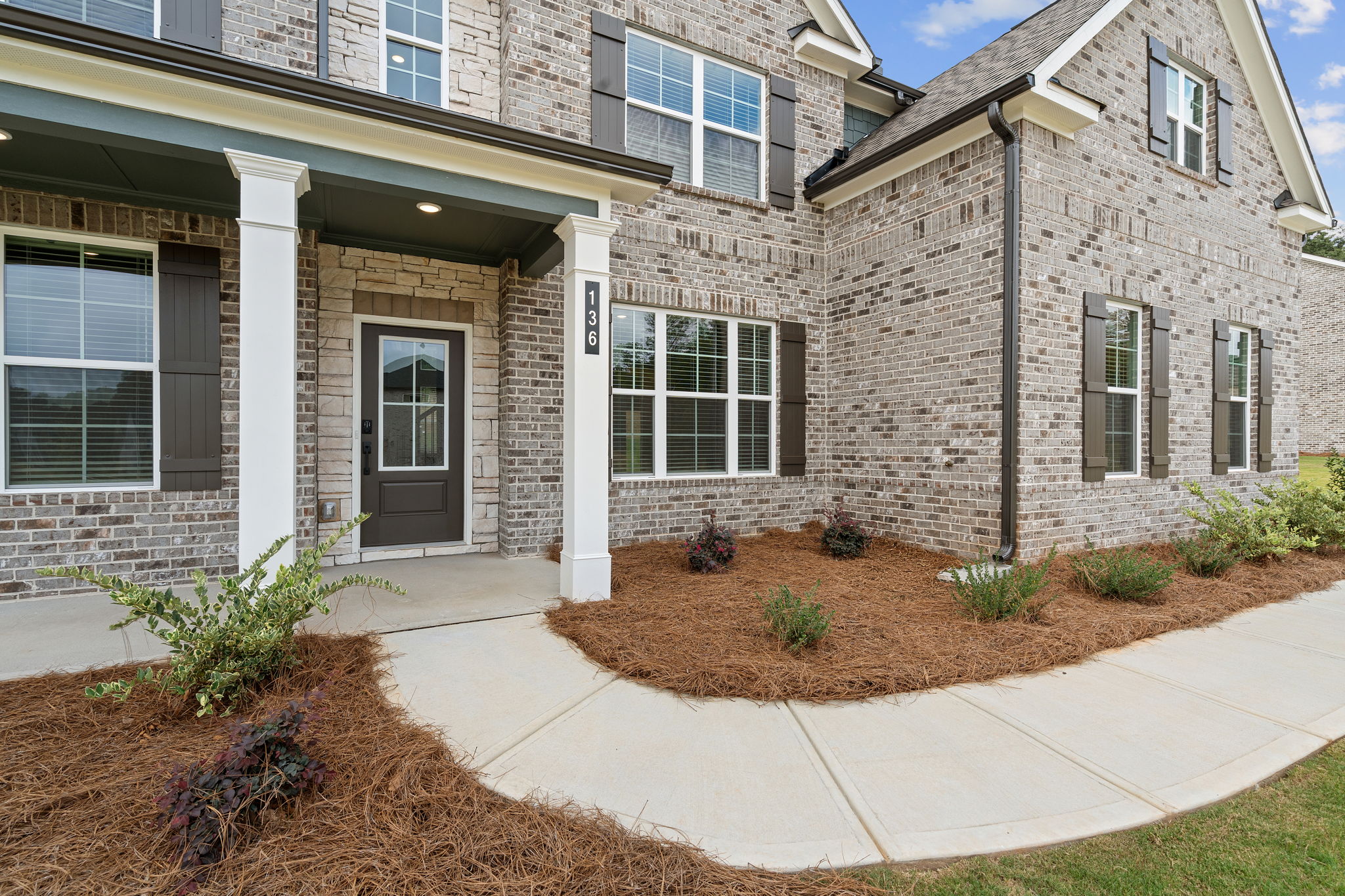 A brick building with a front yard.