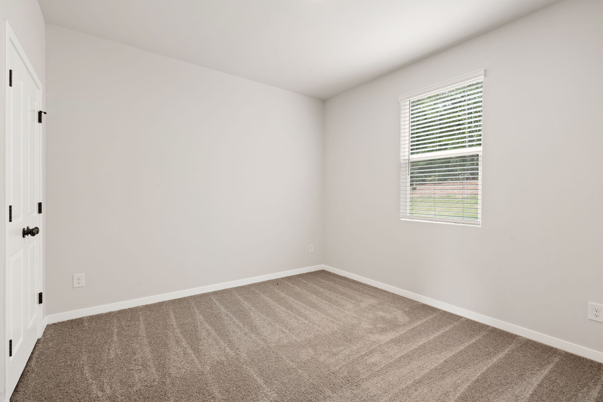 A room with a carpet and a window.