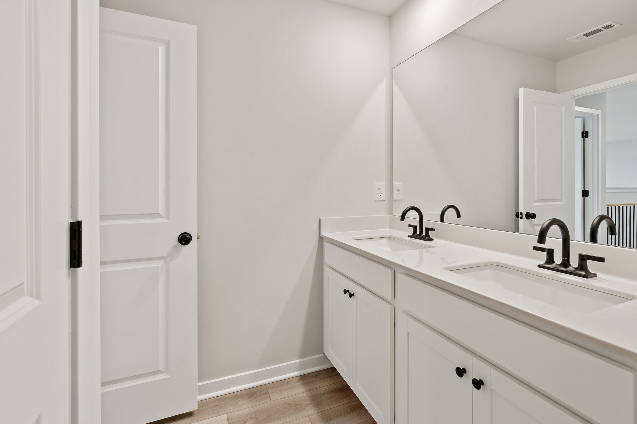 A bathroom with white cabinets.