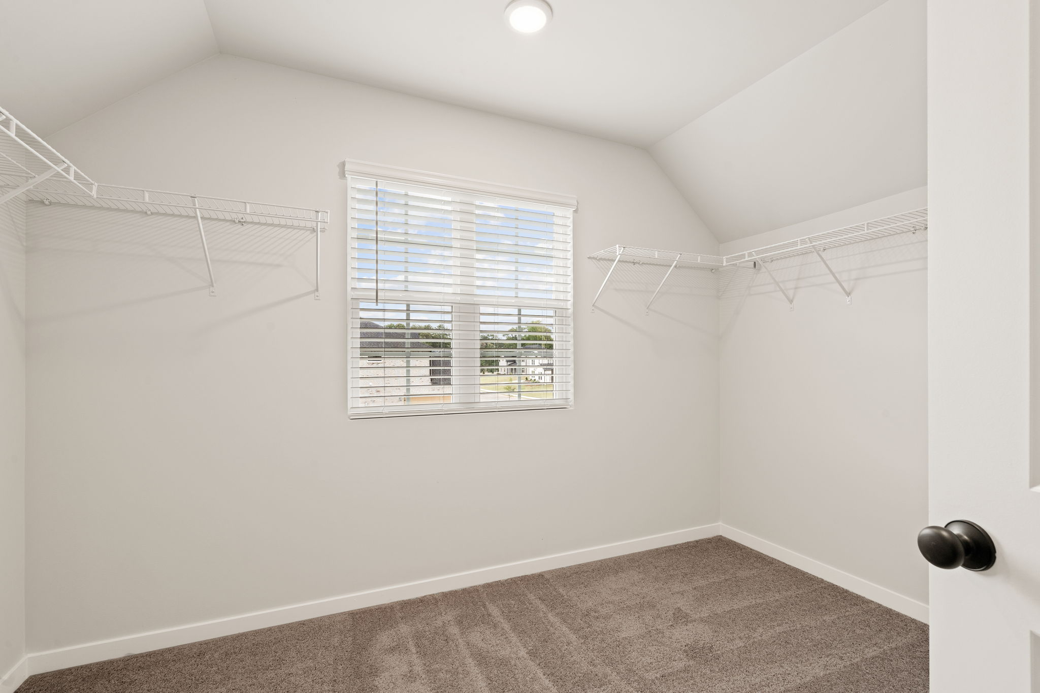 A room with a window and a carpet.