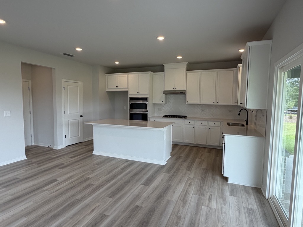 A kitchen with white cabinets.