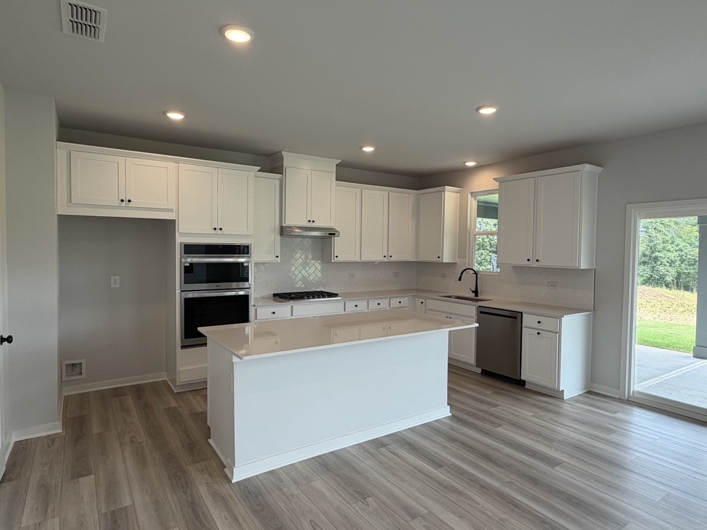 A kitchen with white cabinets.
