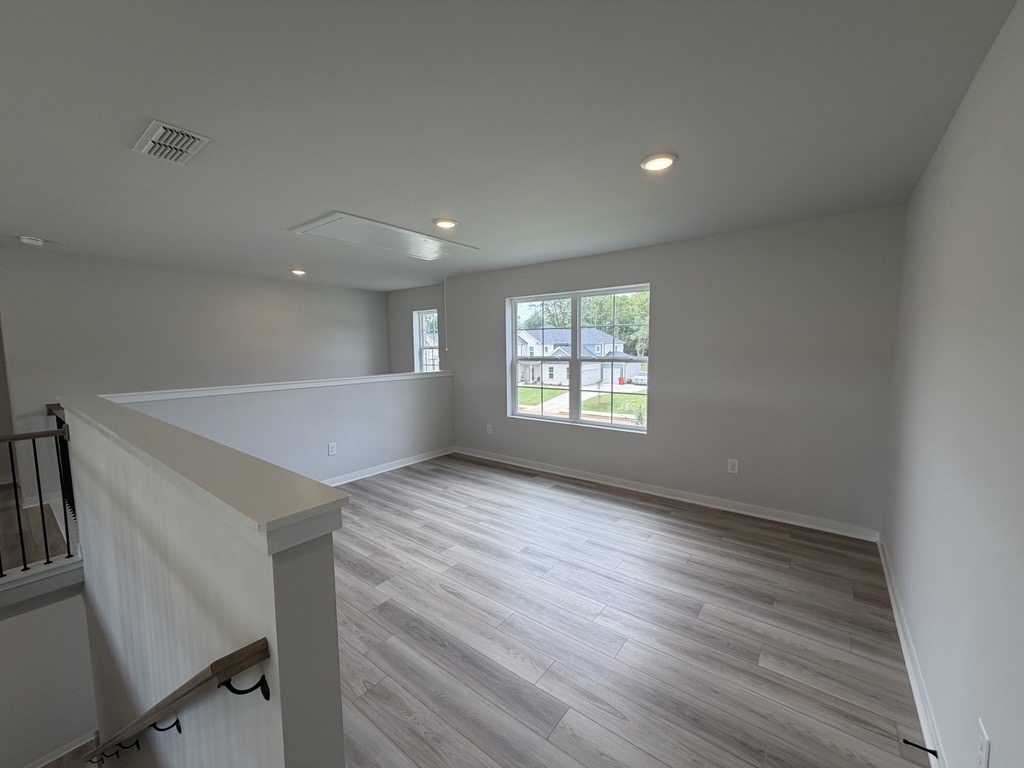 A room with a wood floor and a window.